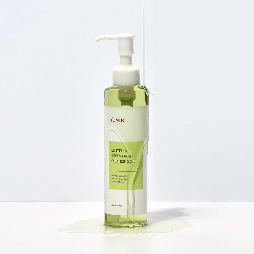 iUNIK Centella Green Fresh Cleansing Oil mit verschüttetem Öl auf weißem Untergrund.