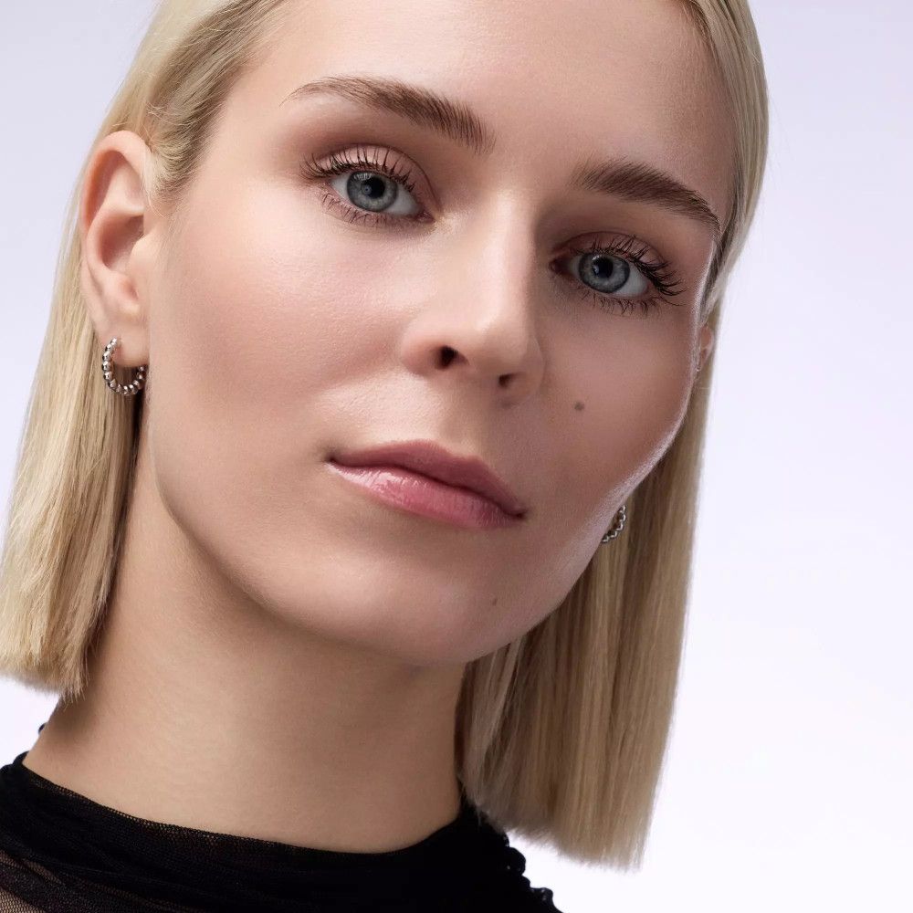 Porträt einer Frau mit blonden Haaren. Aufgetragenes Lippenprodukt, glänzend.