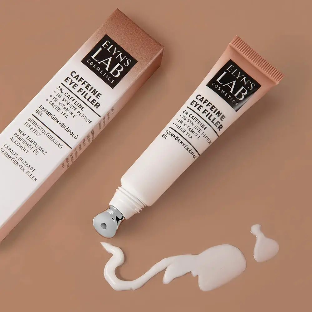 Produkt-Tube mit Roll-on-Applikator und Verpackung. Produktname: ELYN'S LAB Caffeine Eye Filler. Creme-Klecks daneben.