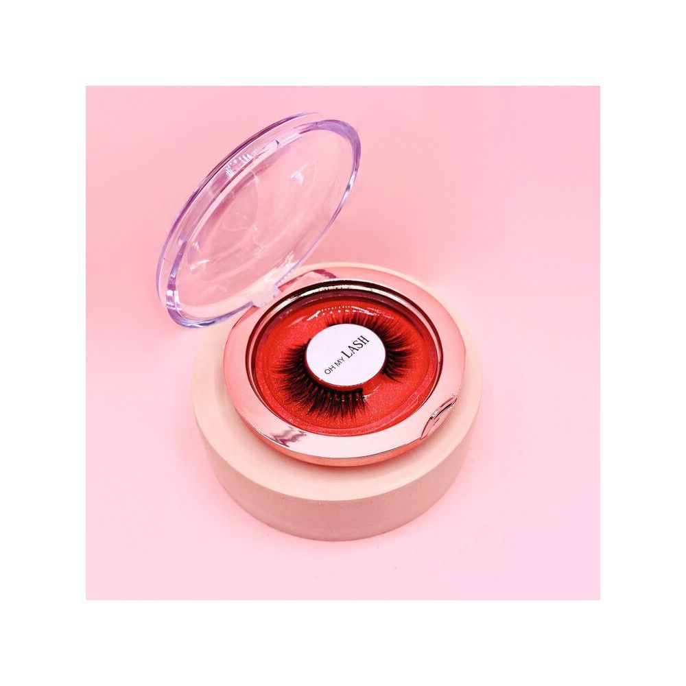Falsche Wimpern in runder, rosafarbener Verpackung. Deckel geöffnet. Auf dem Etikett steht "OH MY LASH".