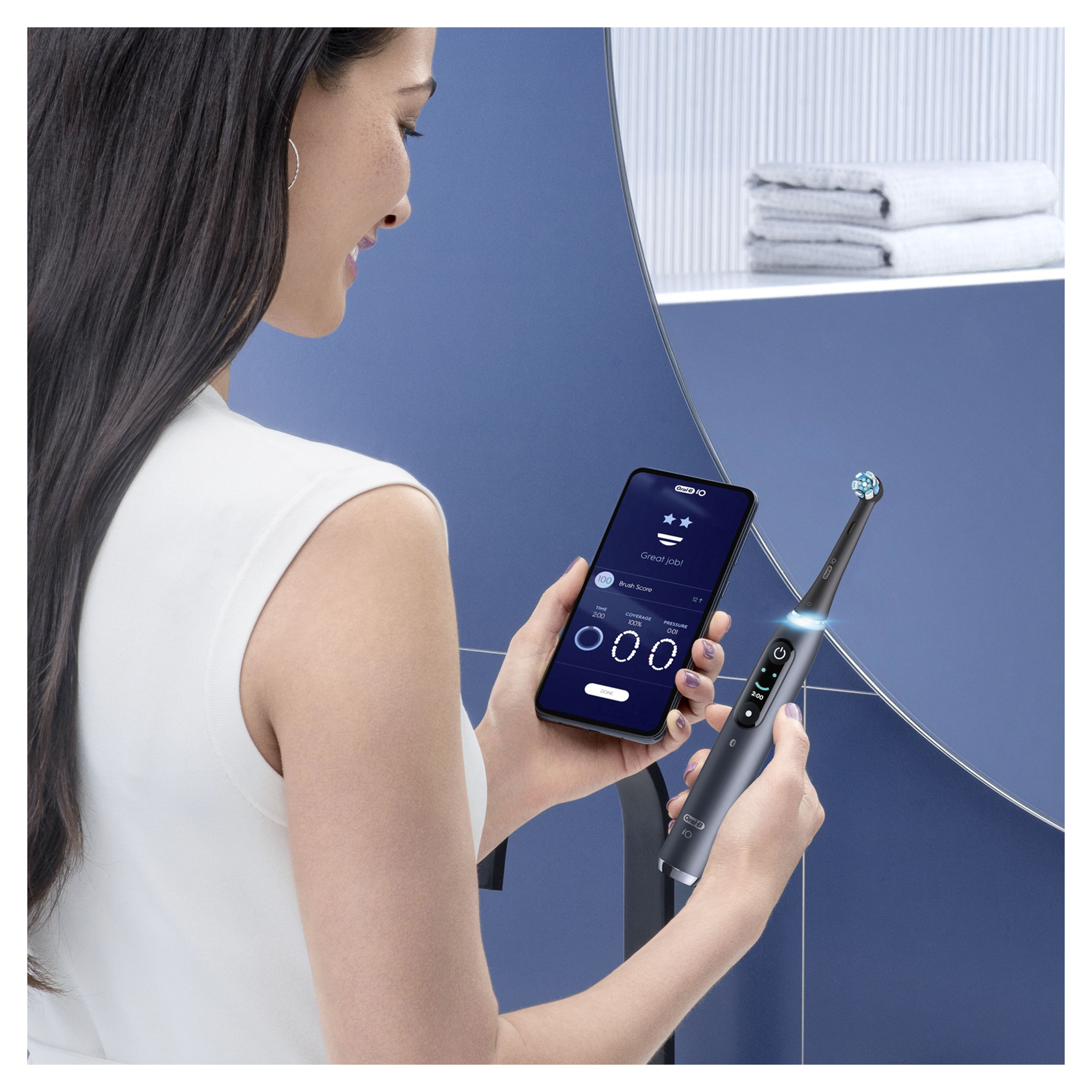 Person hält eine elektrische Zahnbürste und ein Smartphone. Auf dem Smartphone ist eine App mit Zahnputzdaten zu sehen.