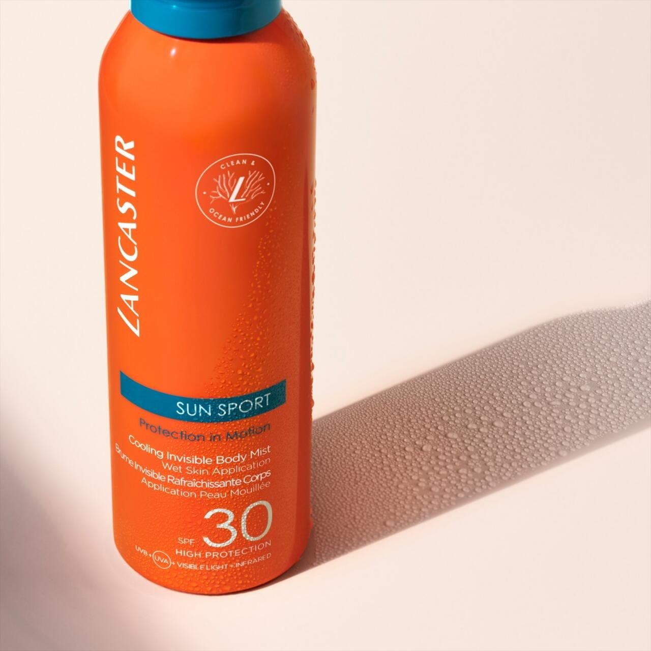 Orangefarbene Sprayflasche mit blauem Deckel. Text: Lancaster, Sun Sport, SPF 30. Vegan-Logo.