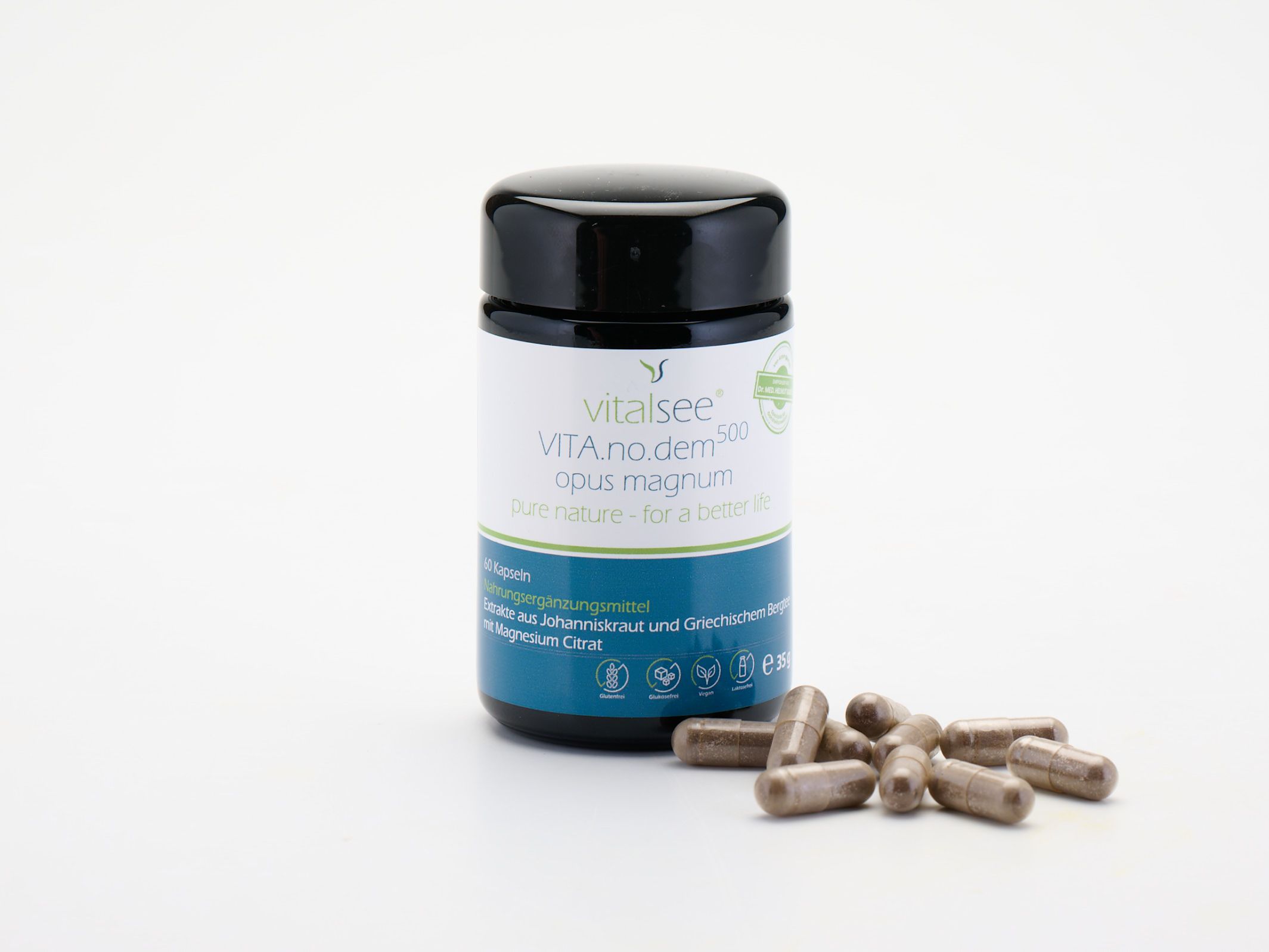 Dose mit Kapseln daneben. Aufschrift: Vitalsee VITA.no.dem 500 opus magnum. 60 Kapseln. Braune Kapseln.