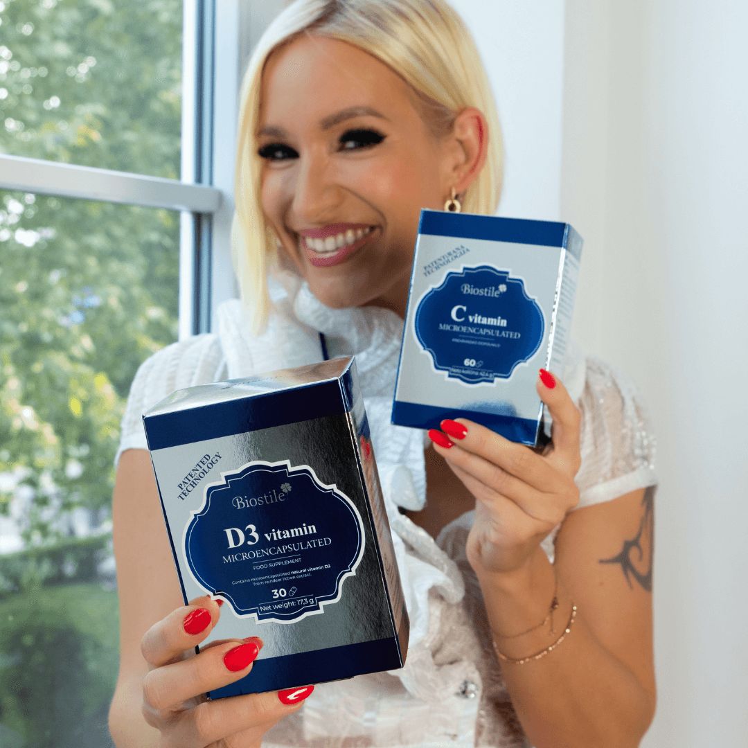 Frau hält zwei Biostile-Produkte: D3 Vitamin und C Vitamin. Beide in Schachteln, mit Produktnamen und Marke.