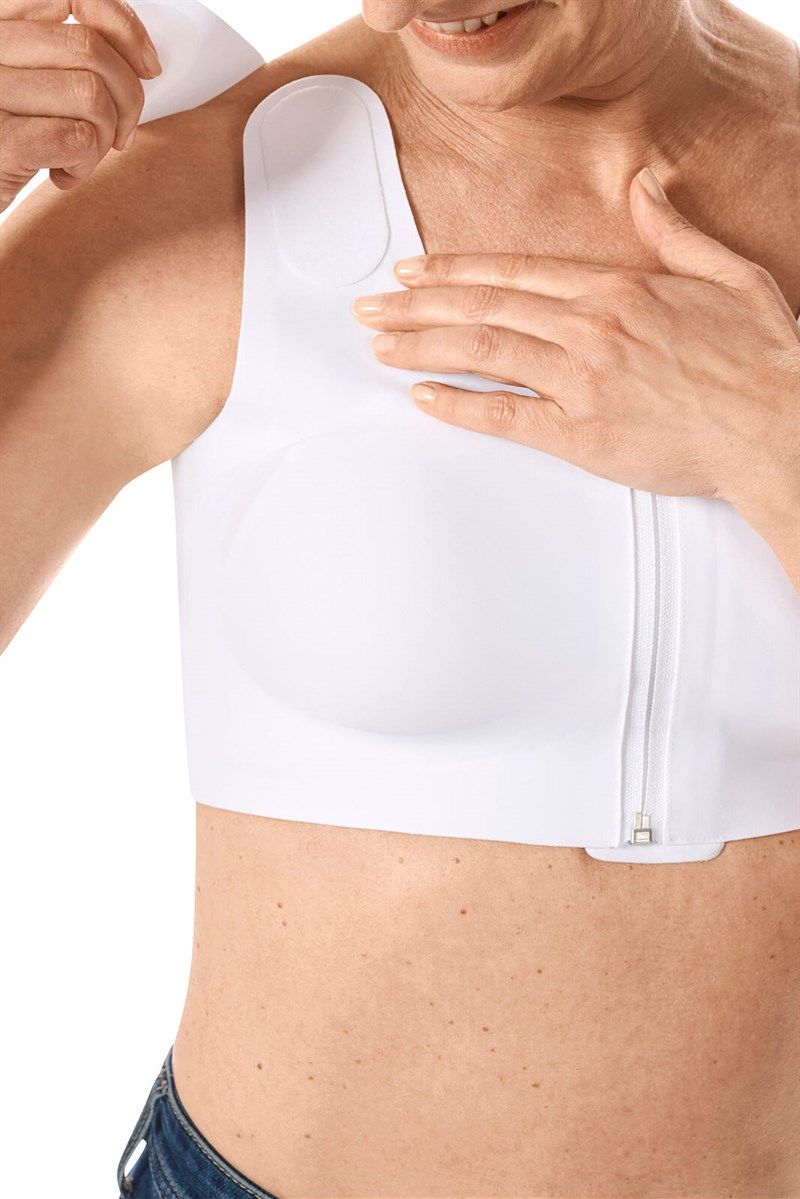 Weißes Oberteil mit Reißverschluss. Person befestigt Schulterpolster. Detailansicht.