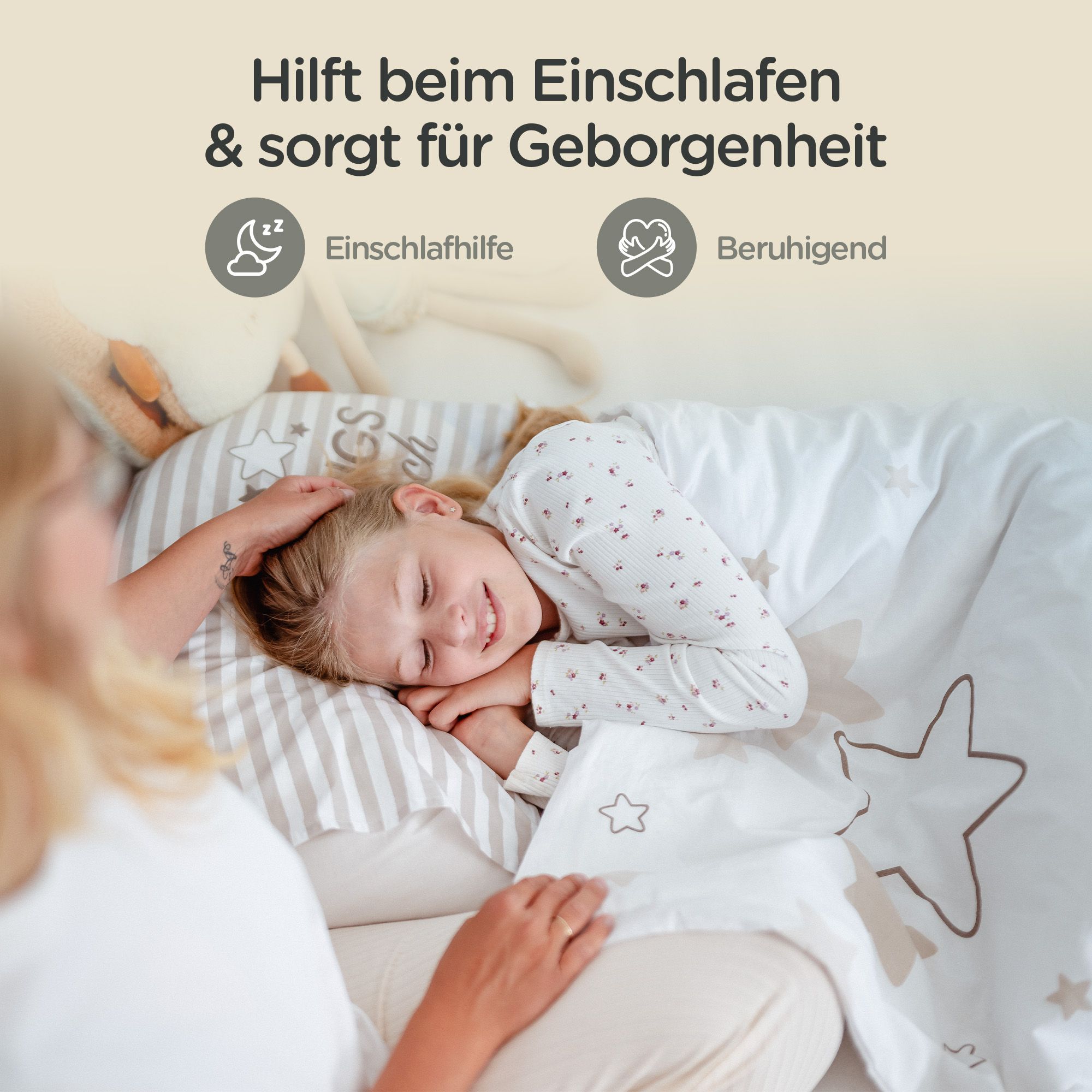 Kind schläft unter weißer Decke mit Sternenmuster. Person berührt das Kind. Text: Einschlafhilfe, beruhigend.