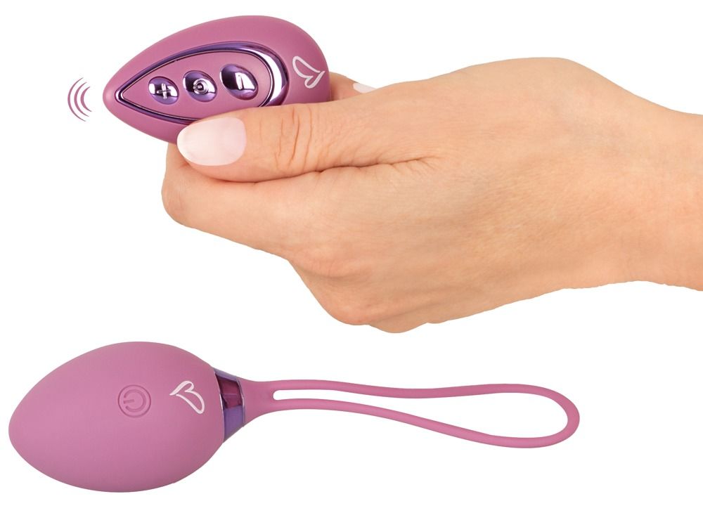 Hand hält eine lila Fernbedienung und eine Vibro-Kugel.
