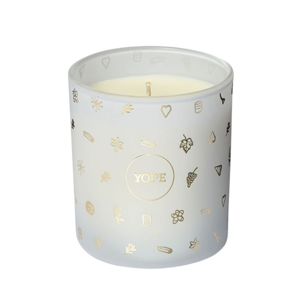 Kerze in einem weißen Glas mit goldenen Verzierungen und dem Logo "YOPE".