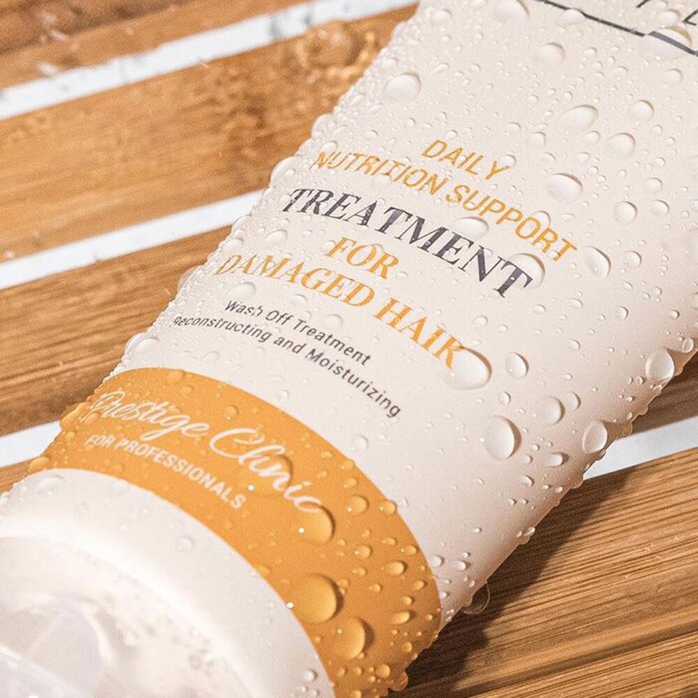 Nahaufnahme einer Tube mit Wassertropfen. Text: DAILY NUTRITION SUPPORT, TREATMENT FOR DAMAGED HAIR. Aufschrift: Prestige Clinic.