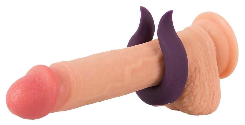 Lila Ring um einen Penis gelegt. Für intime Zwecke. Produkt aus Silikon.