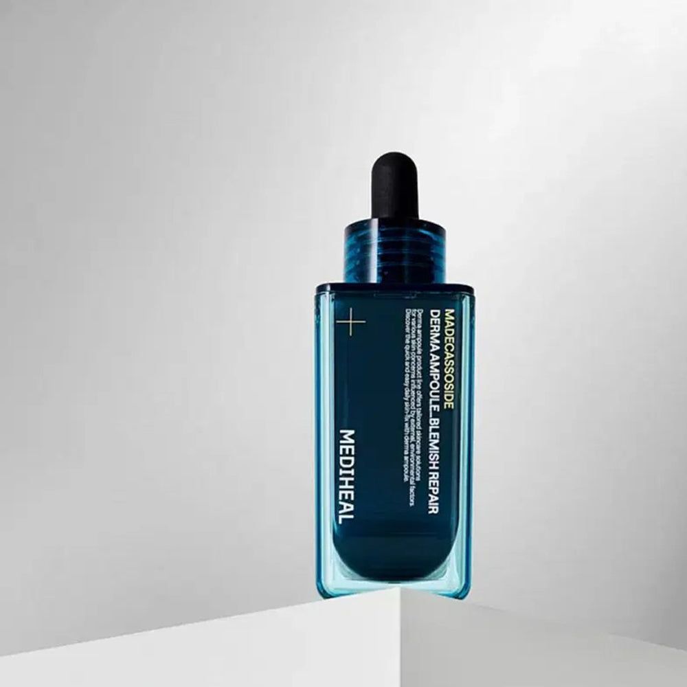 Eine MEDIHEAL Madecassoside Derma Ampulle Blemish Repair Flasche auf einer weißen Oberfläche. Blaue Flasche mit schwarzem Deckel.
