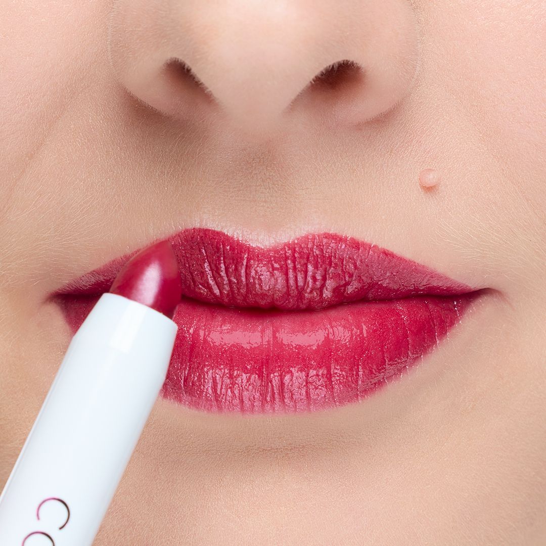Ein Lippenstift wird auf die Lippen aufgetragen. Die Lippen sind mit einem roten Lippenstift bemalt.