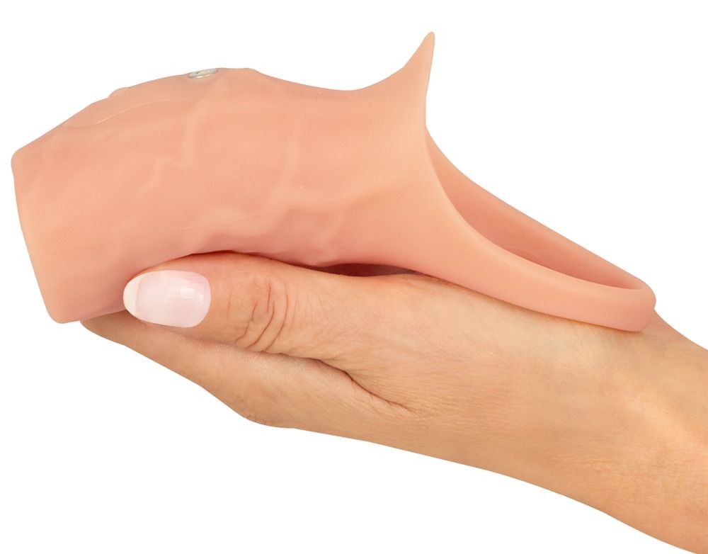 Penismanschette mit Hodenring. Hautfarbenes Silikon. Gehalten von einer Hand. Ringförmige Basis.