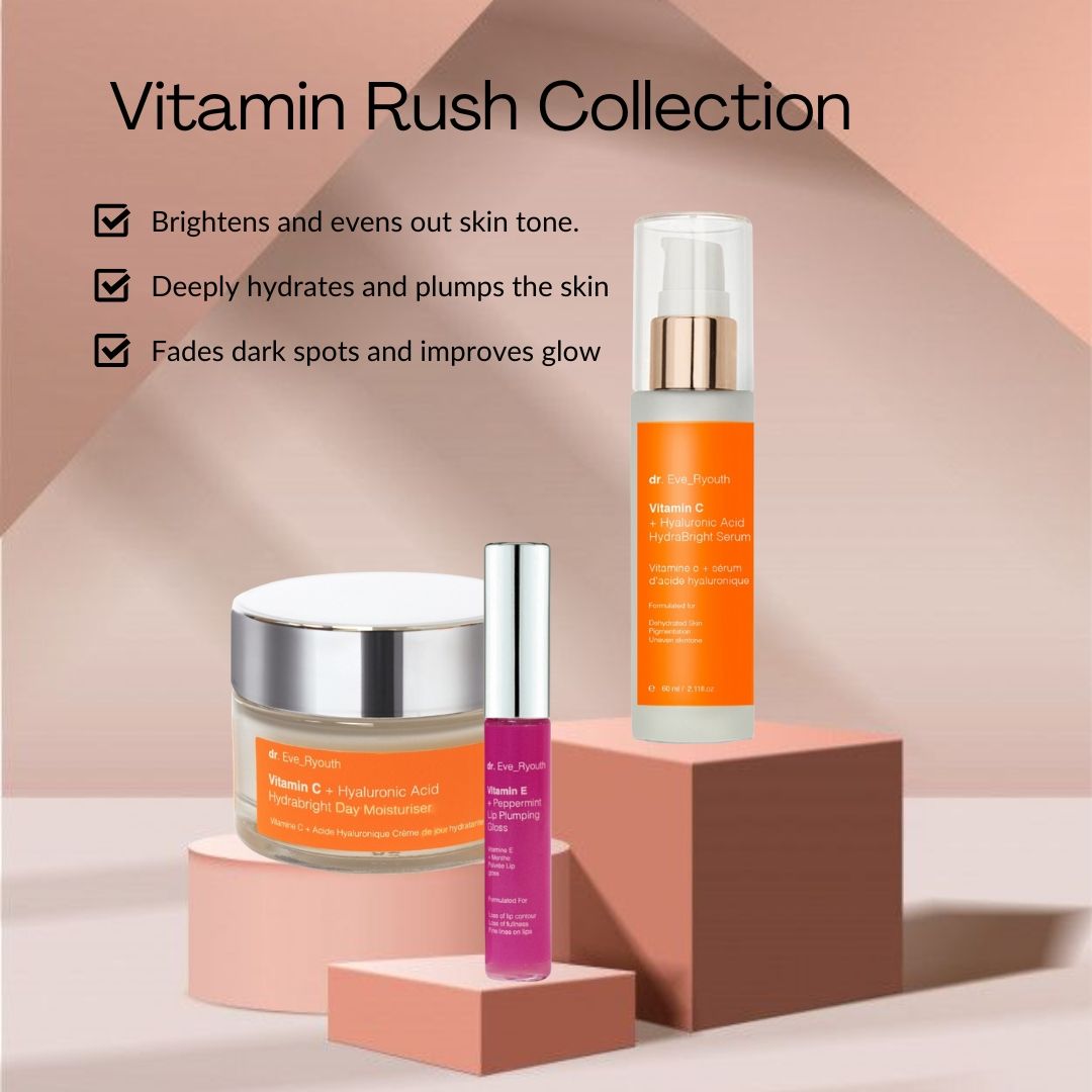 Kosmetikprodukte auf Podest: Creme, Serum, Lipgloss. Creme- und Serumbehälter mit orangefarbenen Etiketten. Lipgloss in pinkfarbener Hülle.