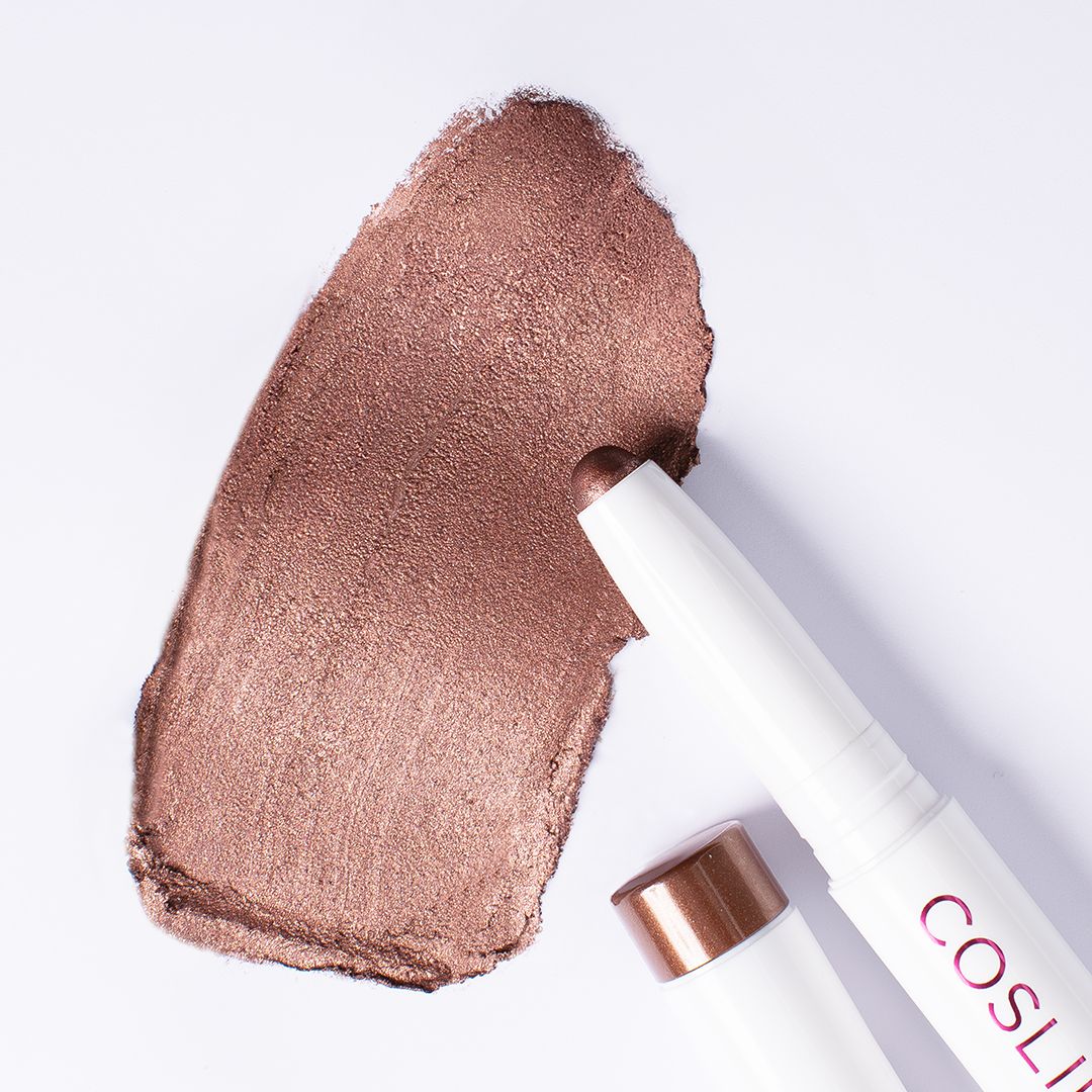 Bronze-Lidschatten-Swatch und zwei weiße Stifte von Cosline. Produkt-Enden in Bronze-Farbe. Aufschrift: Eyeshadow 309 Bronce.