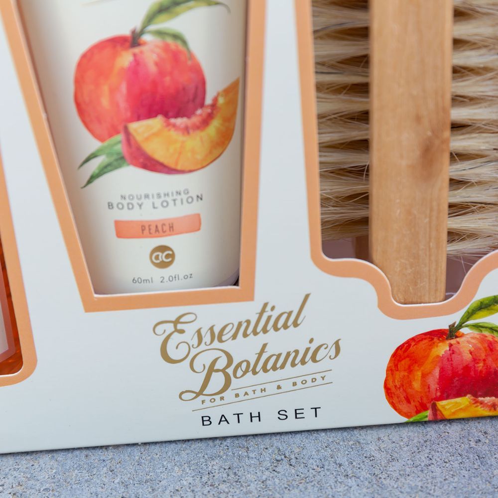 Detailansicht der Geschenkbox. Zeigt den Schriftzug "Essential Botanics" und "Bath Set". Pfirsich-Illustrationen.