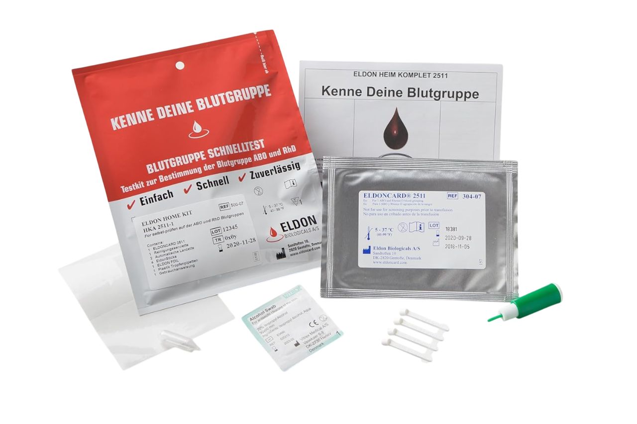 Blutgruppenschnelltest-Kit. Rote und silberne Verpackungen, Testkarten, Lanzetten und Anleitungen. Schriftzug: Kenne Deine Blutgruppe.