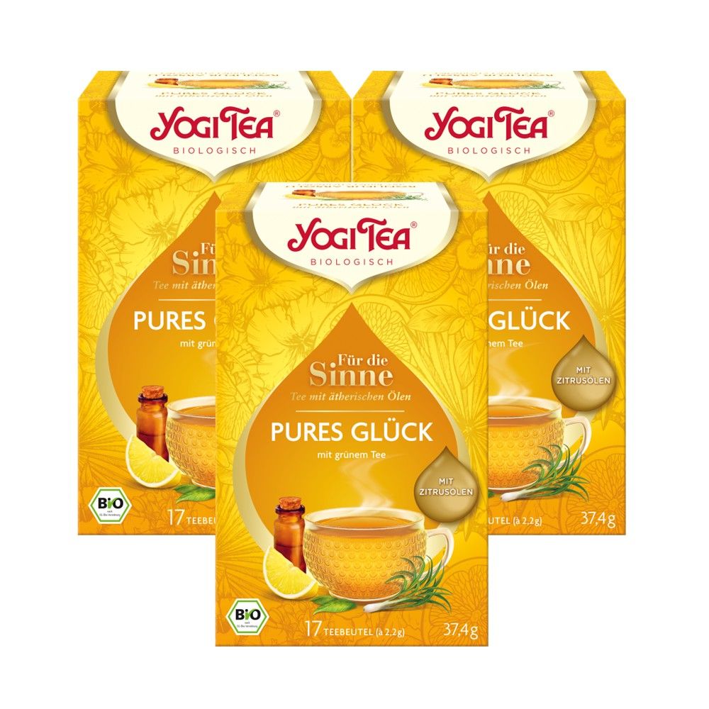 Drei gelbe Teepackungen mit Aufschrift "Yogi Tea". Aufdruck "Pures Glück" und "Bio".