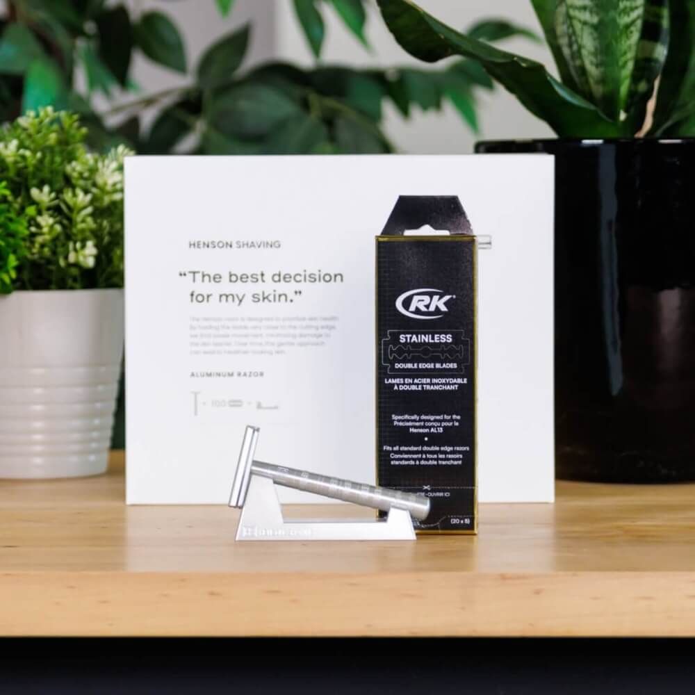 Rasierer und Klingen in Verpackung. Text: RK, STAINLESS DOUBLE EDGE BLADES. Rasierer auf Halterung.