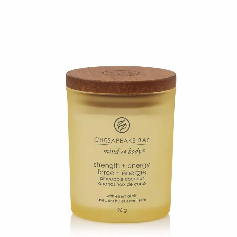 Gelbe Kerze mit Holzdeckel. Aufschrift Chesapeake Bay mind & body, Stärke + Energie, Ananas Kokosnuss. 96 g.
