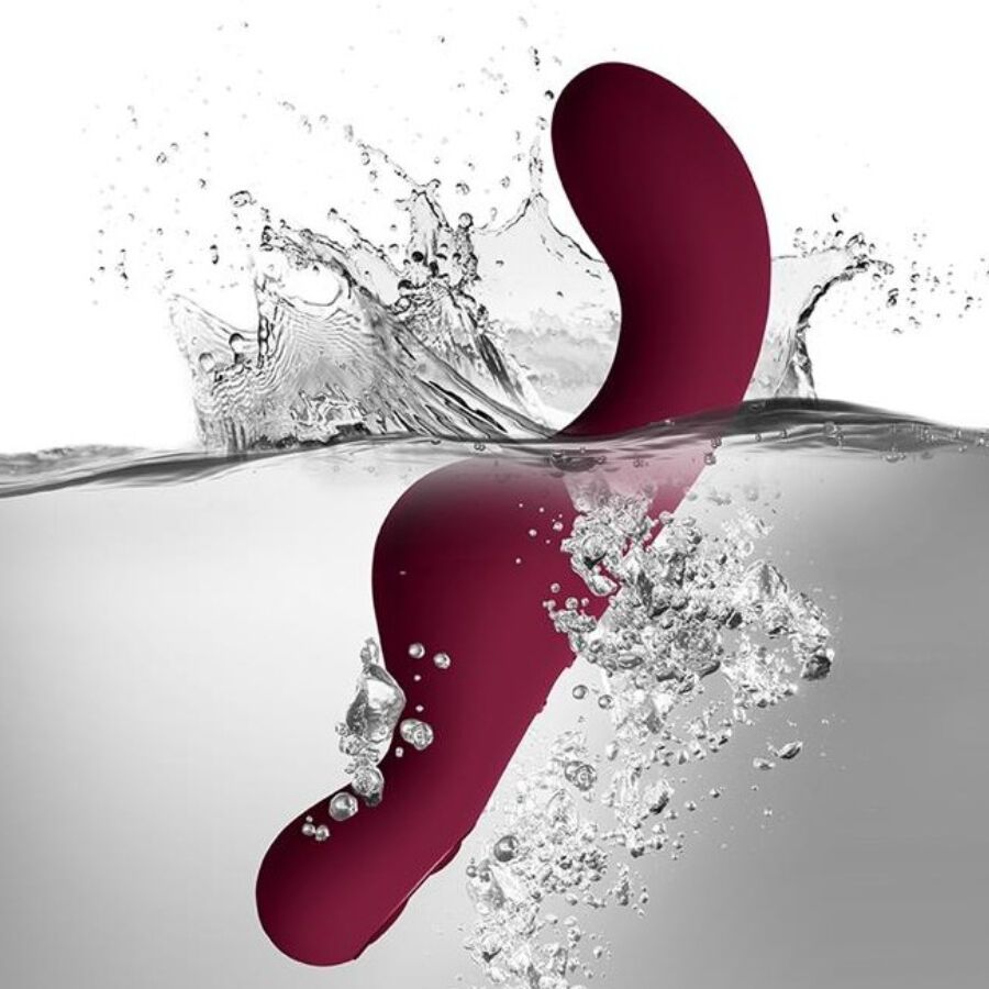 Roter Vibrator taucht in Wasser mit Spritzern.