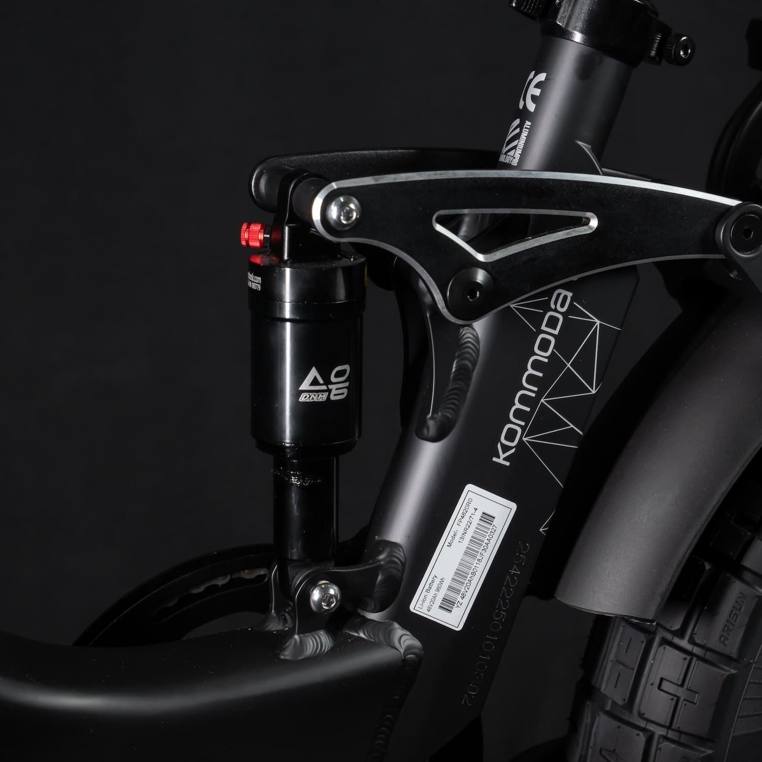 Nahaufnahme des hinteren Stoßdämpfers und des Rahmens. Das Wort Kommoda ist auf dem Rahmen sichtbar.