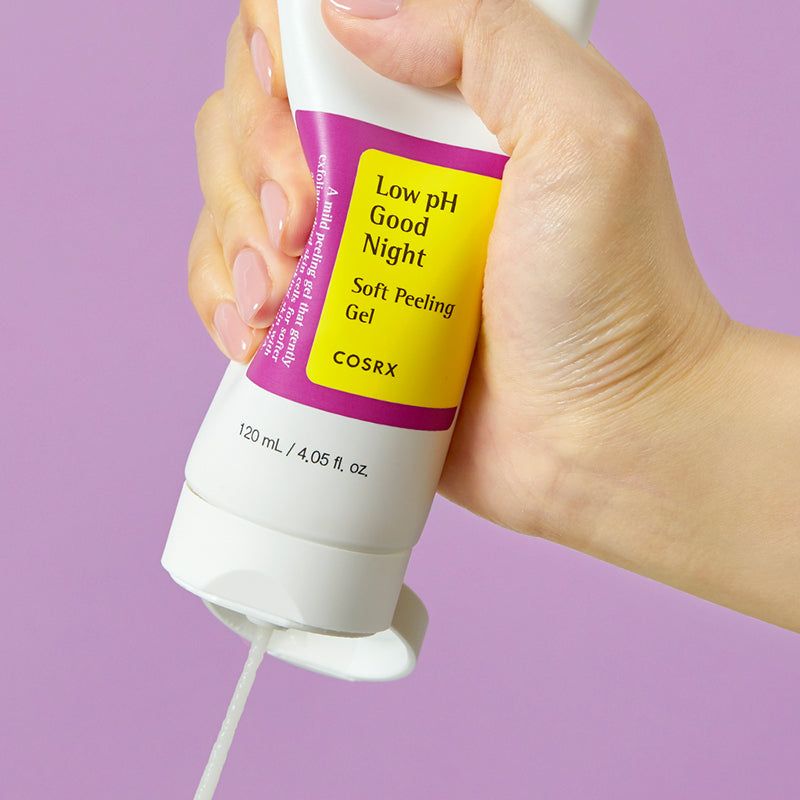Weiße Tube mit gelb-lila Etikett. Produkt wird ausgedrückt. Aufschrift: Low pH Good Night Soft Peeling Gel. Marke: COSRX. Volumen: 120 ml.