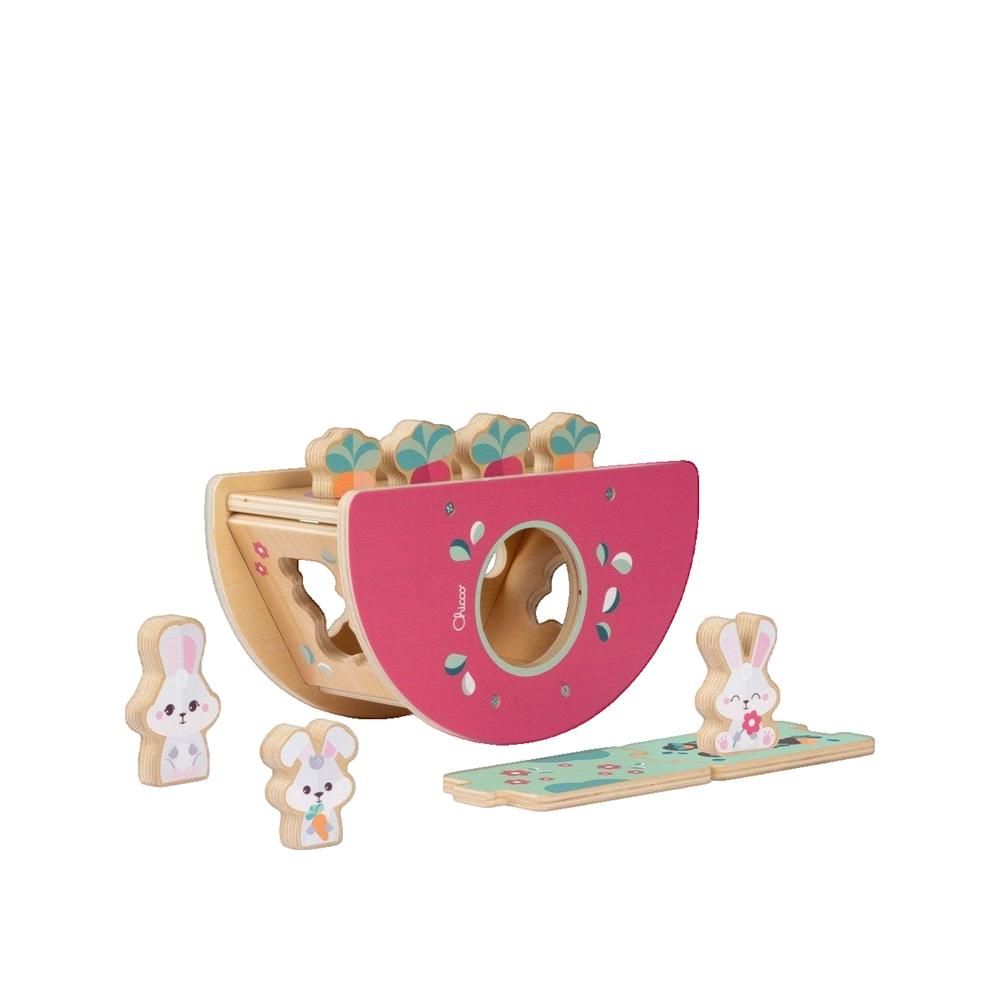 Rosa Holzwippe mit bunten Elementen und Hasenfiguren. Mehrere Hasenfiguren und ein Brett liegen daneben.