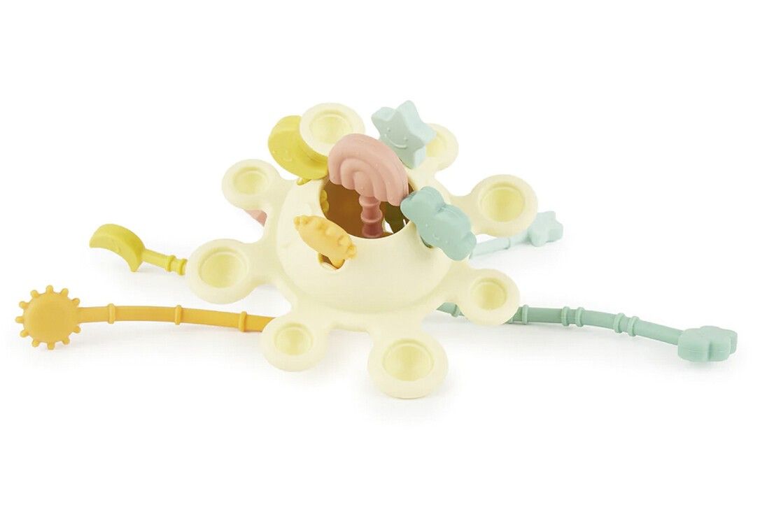 Gelbes Spielzeug mit farbigen Anhängern. Anhänger in Form von Stern, Wolke, Schaufel, Sonne und Sichel. Ansicht von oben.