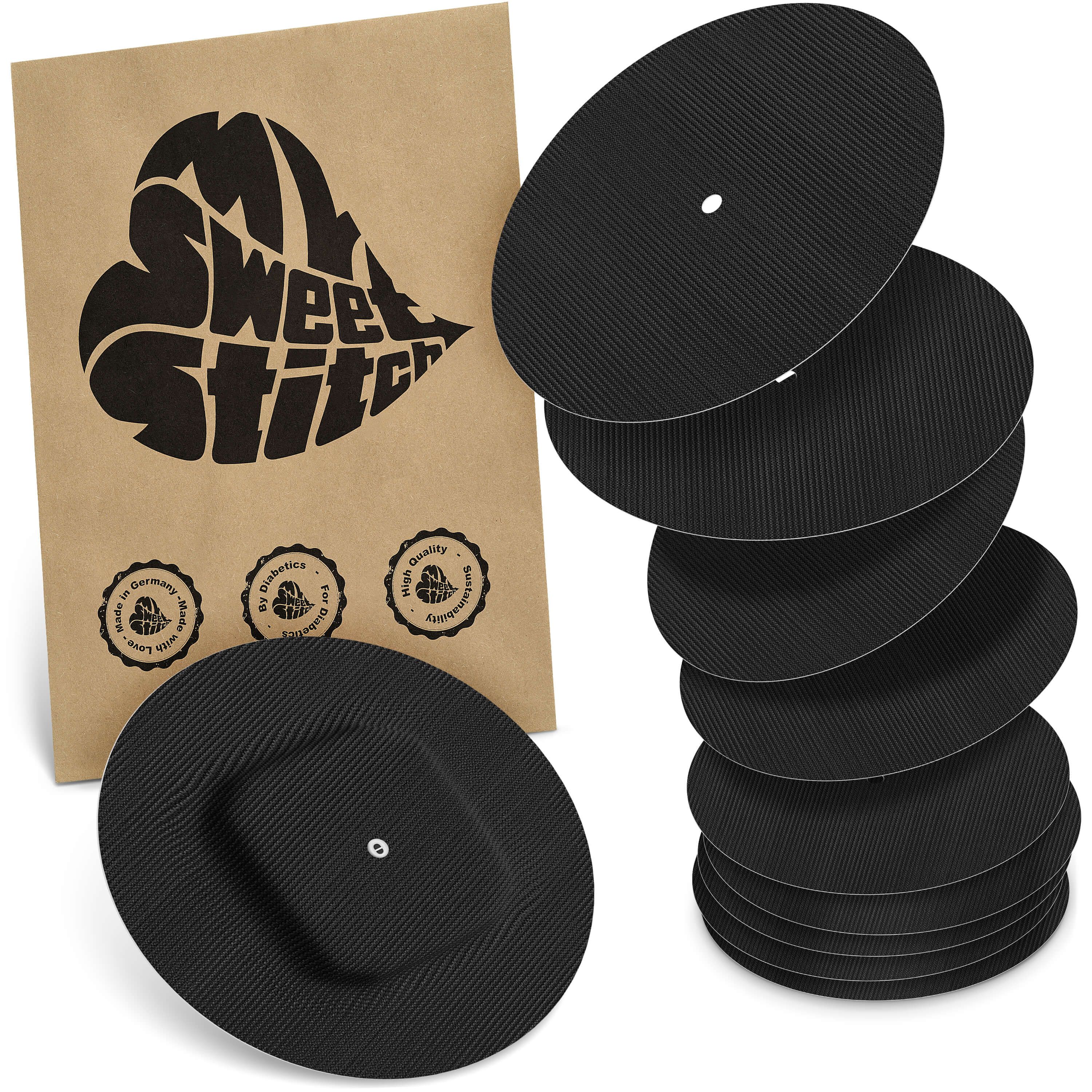 Schwarze, runde Simplera Overpatch. Verpackung mit Logo. Mehrere Patches gestapelt. Zertifizierungen sichtbar.