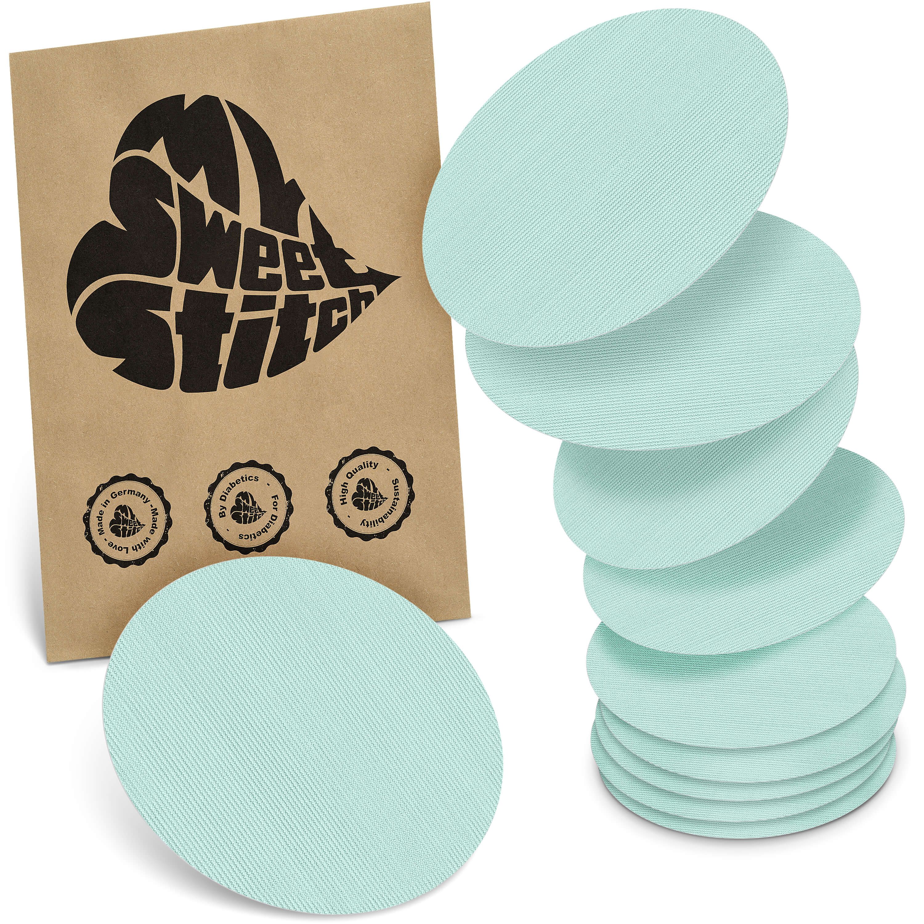 Mehrere ovale, hellblaue Pflaster. Braune Verpackung mit Logo und Siegeln.