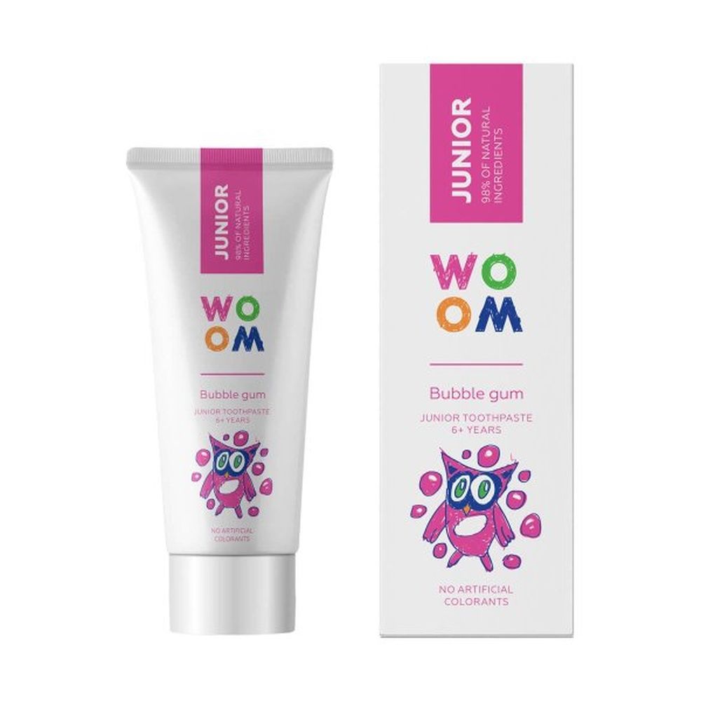 Zahncreme-Tube und Schachtel. Rosa Akzente. Aufschrift "JUNIOR" und "WOOM". Monster-Illustration. "Bubble gum" und "6+ years".