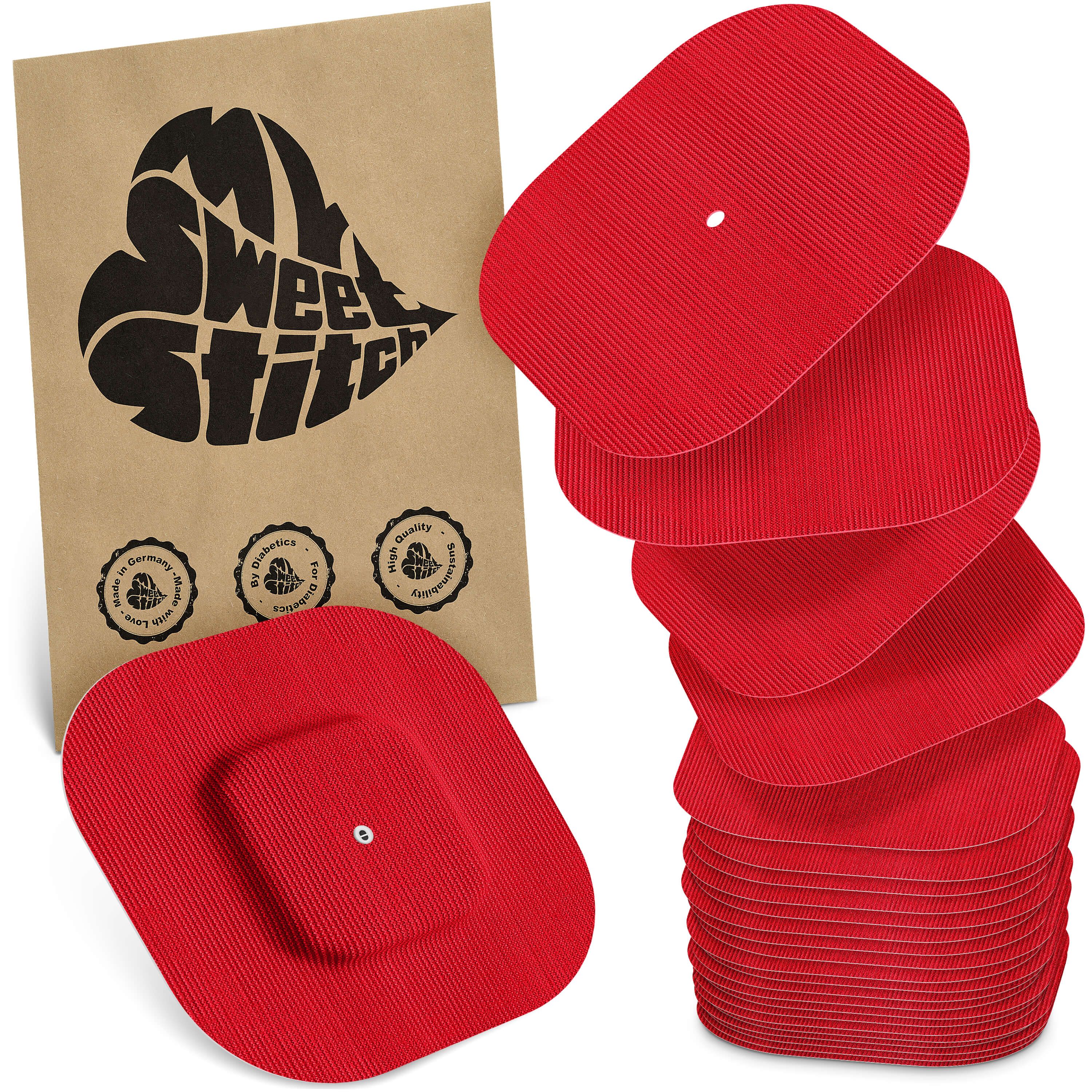 Rote Pflaster mit Rillenstruktur, einige gestapelt, eines mit zentraler Erhebung. Braune Verpackung mit Herz-Logo und Qualitätssiegeln.