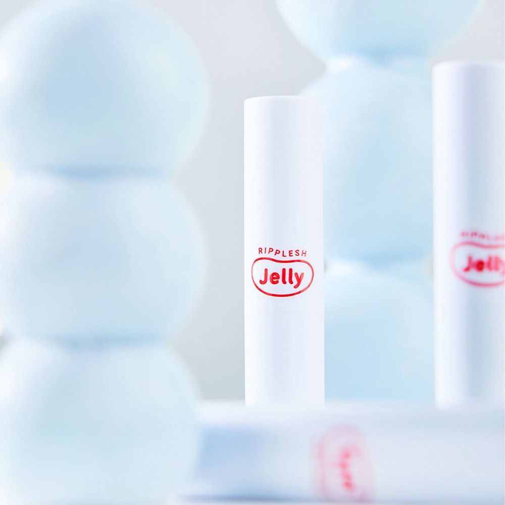 Mehrere weiße Lippenbalsam-Tuben mit rotem "Ripplesh Jelly"-Logo. Hintergrund mit blauen Kugeln.