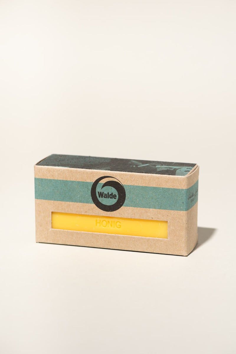 Seife in Kartonverpackung. Auf der Verpackung steht "Walde" und "Honig". Die Seife ist gelb.