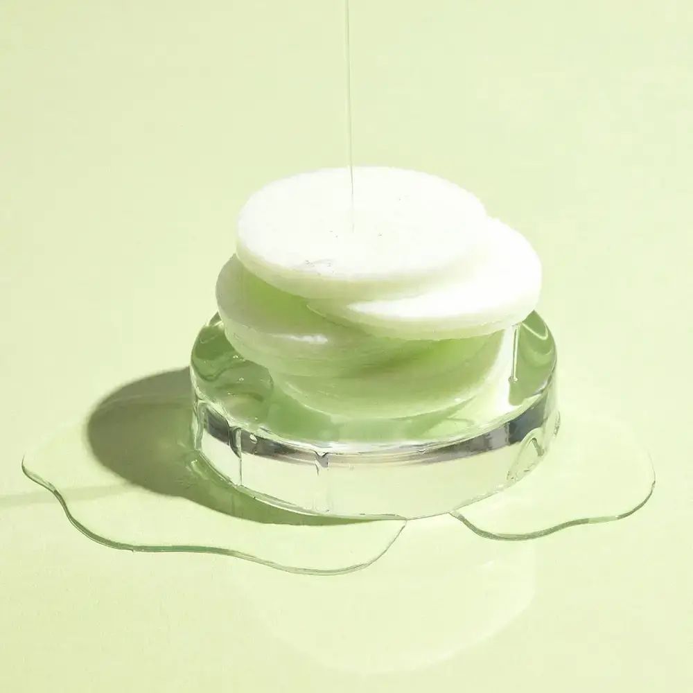 Grüne, runde Pads auf einer transparenten Halterung. Flüssigkeit tropft auf die Pads.