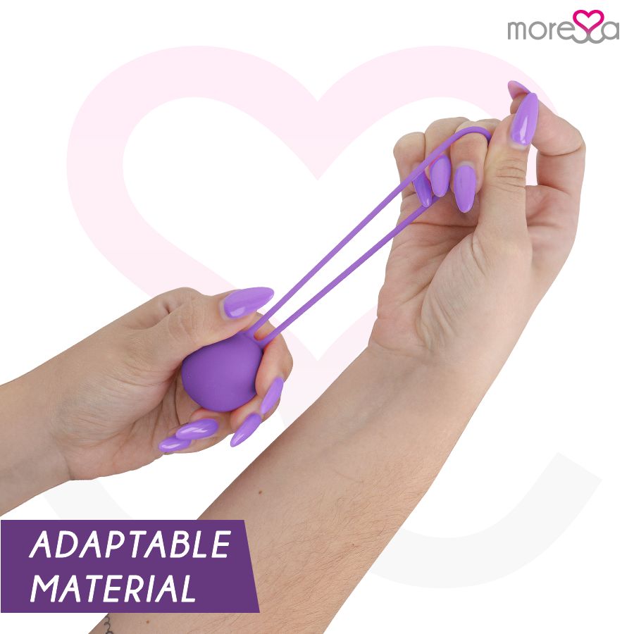 Hände halten eine lila Silikonkugel mit Schnur. "ADAPTABLE MATERIAL" Aufdruck.