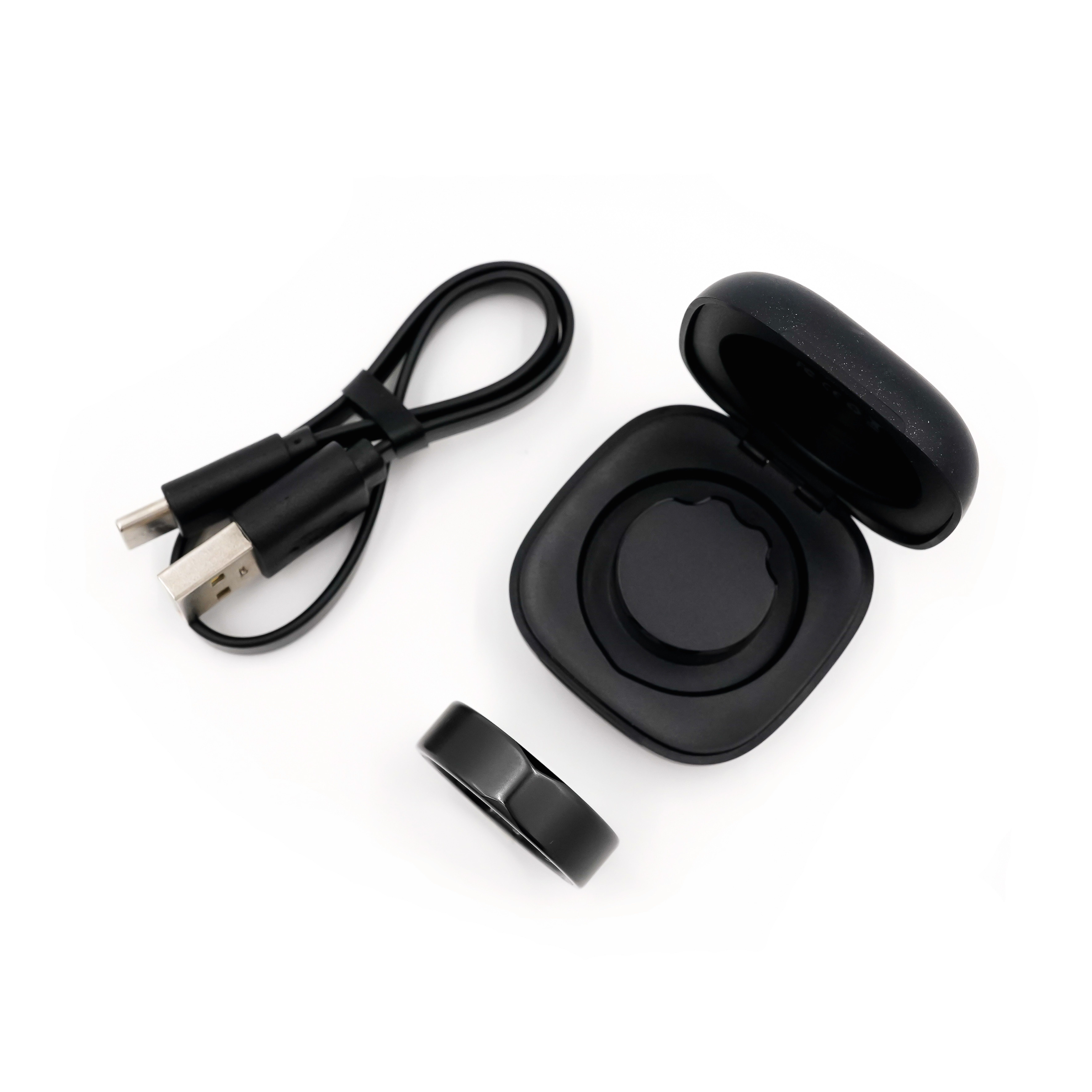 Ring, Ladestation, Kabel. Schwarze Komponenten. Offene Verpackung.