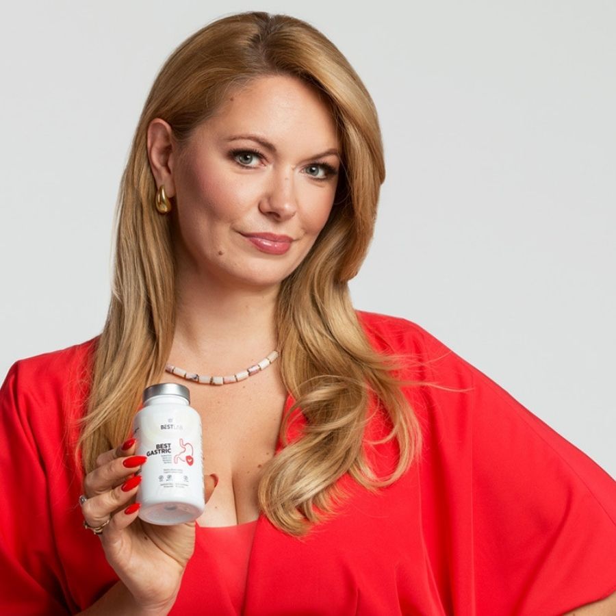 Frau hält eine weiße Flasche mit grauen Deckel. Aufschrift: BEST LAB BEST GASTRIC. Rotes Magen-Symbol. Frau trägt rotes Kleid.
