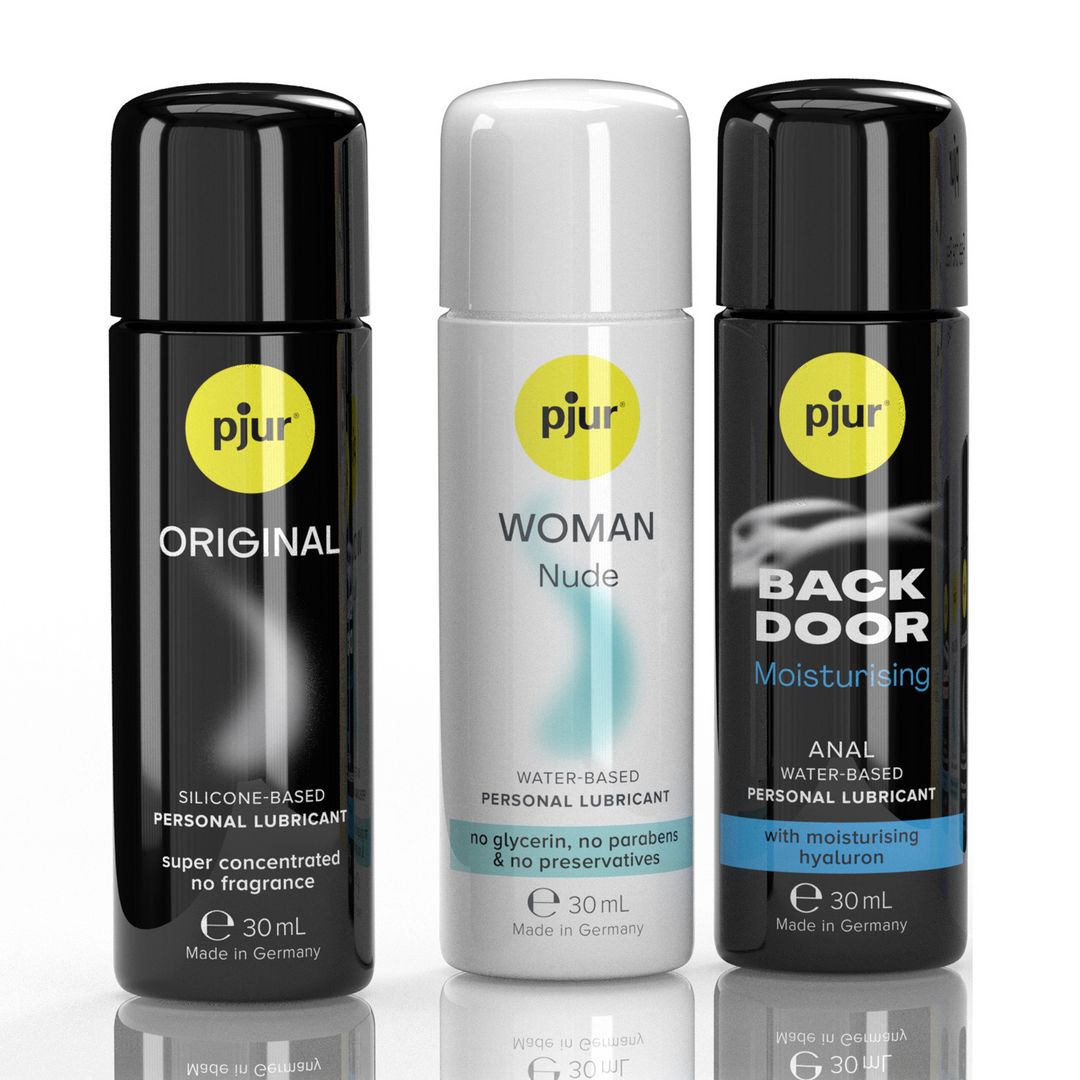 Drei Flaschen Gleitmittel. Aufdruck: pjur, Original, Woman Nude, Back Door. Schwarze und weiße Flaschen mit gelben Etiketten. Text: Personal Lubricant.
