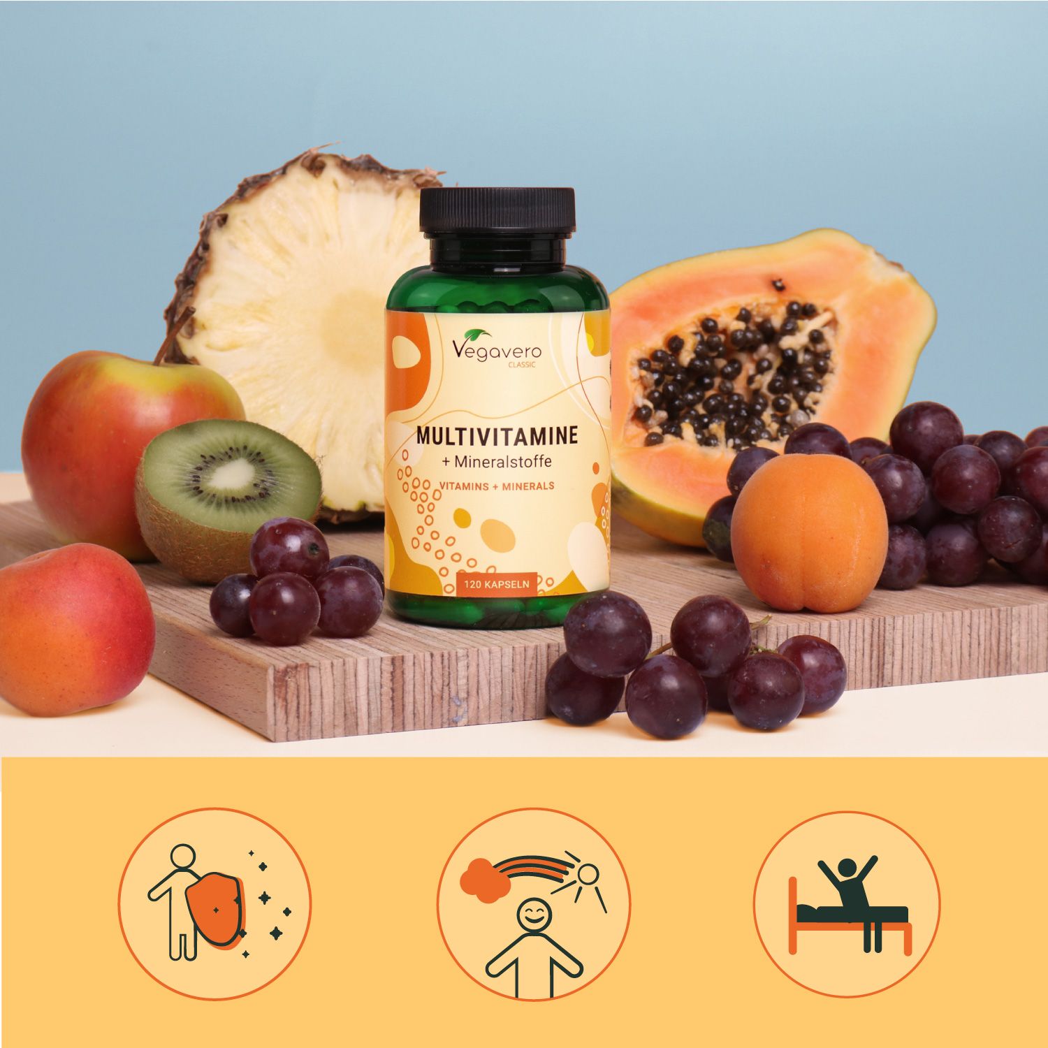 Eine Flasche VEGAVERO Multivitamine + Mineralstoffe, umgeben von Obst: Apfel, Kiwi, Trauben, Papaya und Aprikosen. Auf Holzbrett.