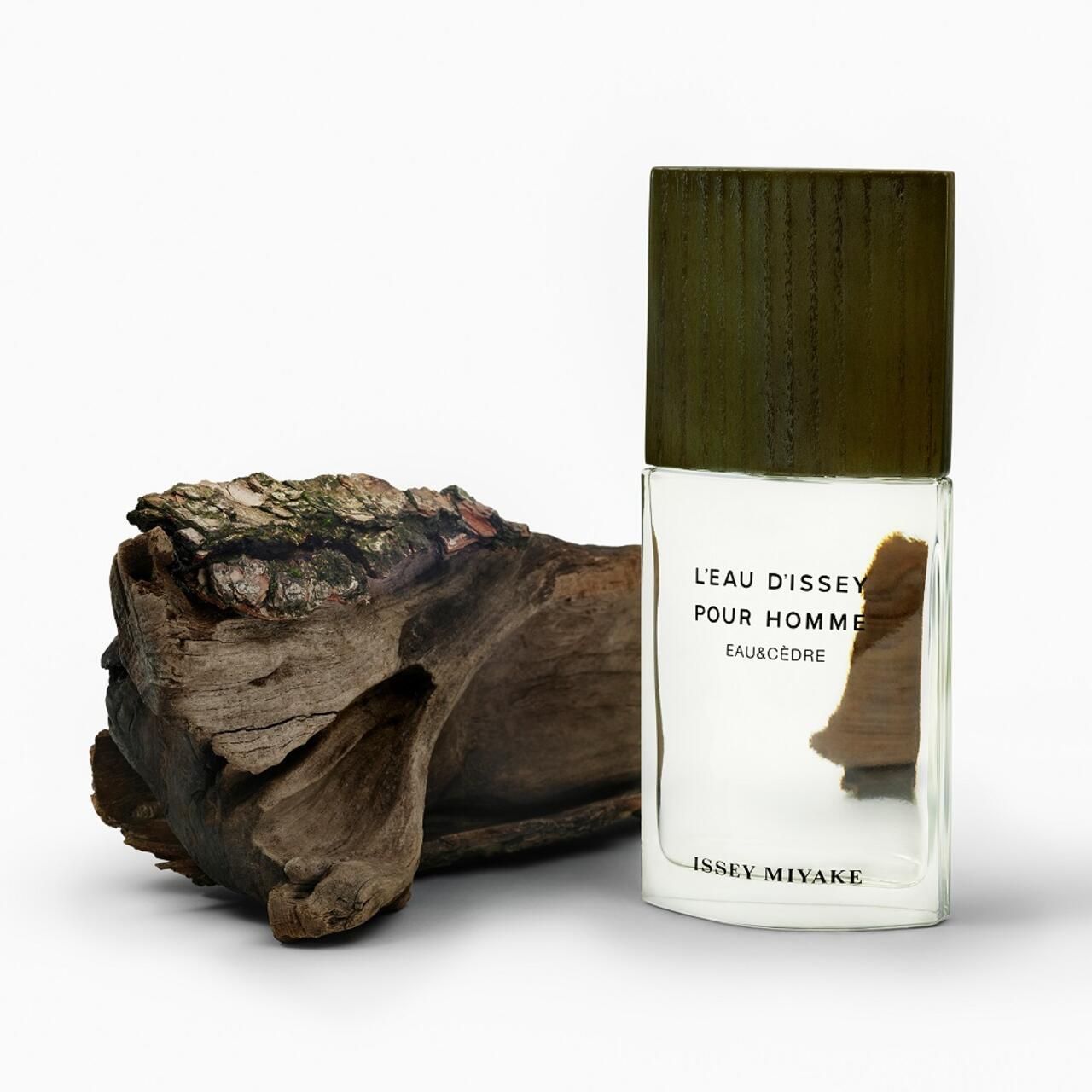 Flakon neben Holzstück. Aufschrift: L'EAU D'ISSEY POUR HOMME EAU&CÈDRE. Marke: ISSEY MIYAKE.