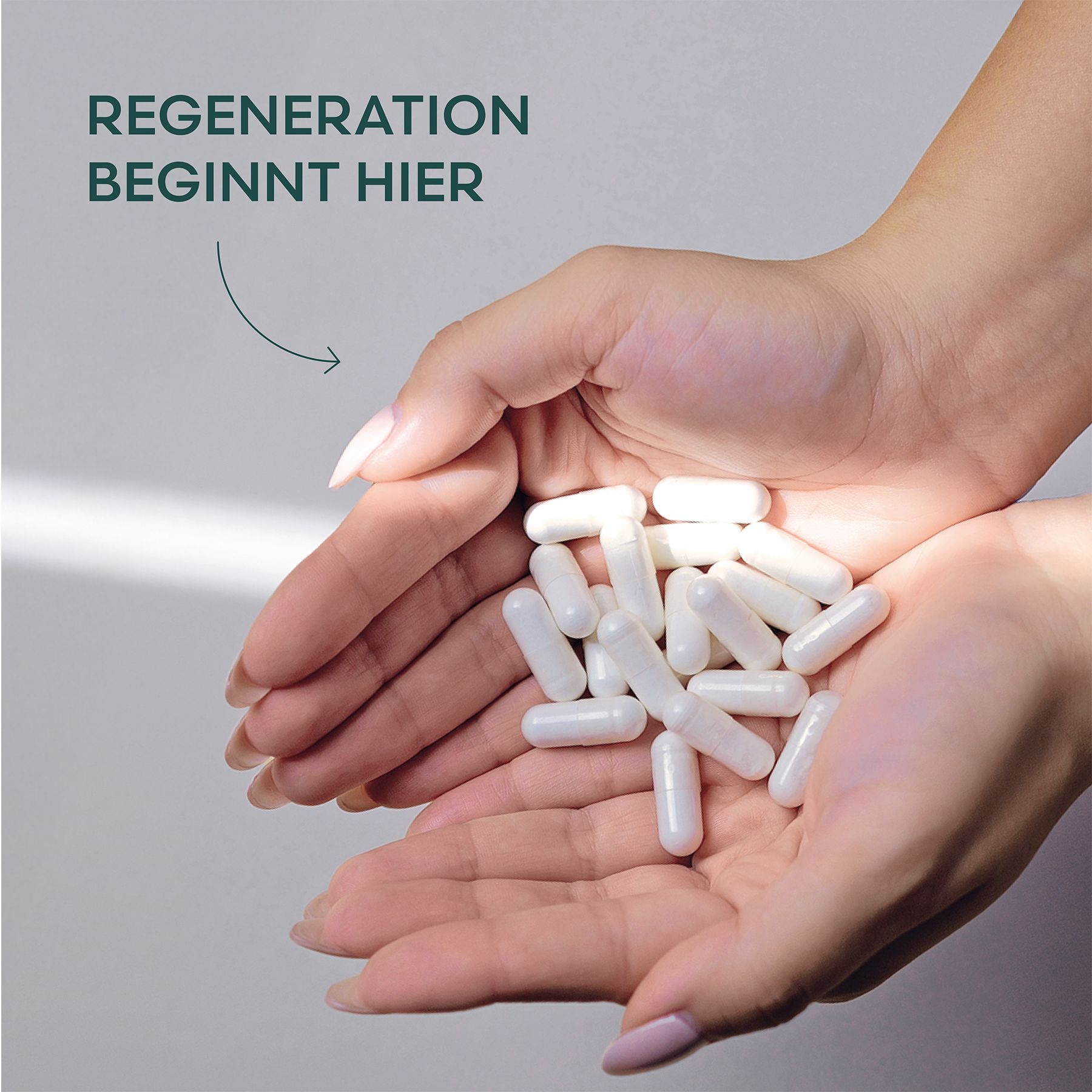 Hände halten Kapseln. Text: Regeneration beginnt hier. Weiße Kapseln in Händen. Nägel lackiert.