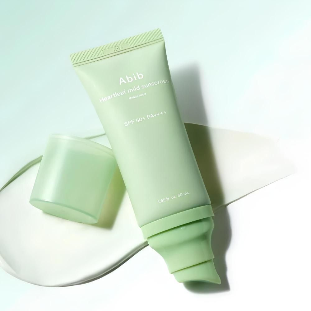 Abib Heartleaf Mild Sonnenschutzmittel SPF 50+ PA++++ mit geöffnetem Deckel auf einer cremigen Unterlage.