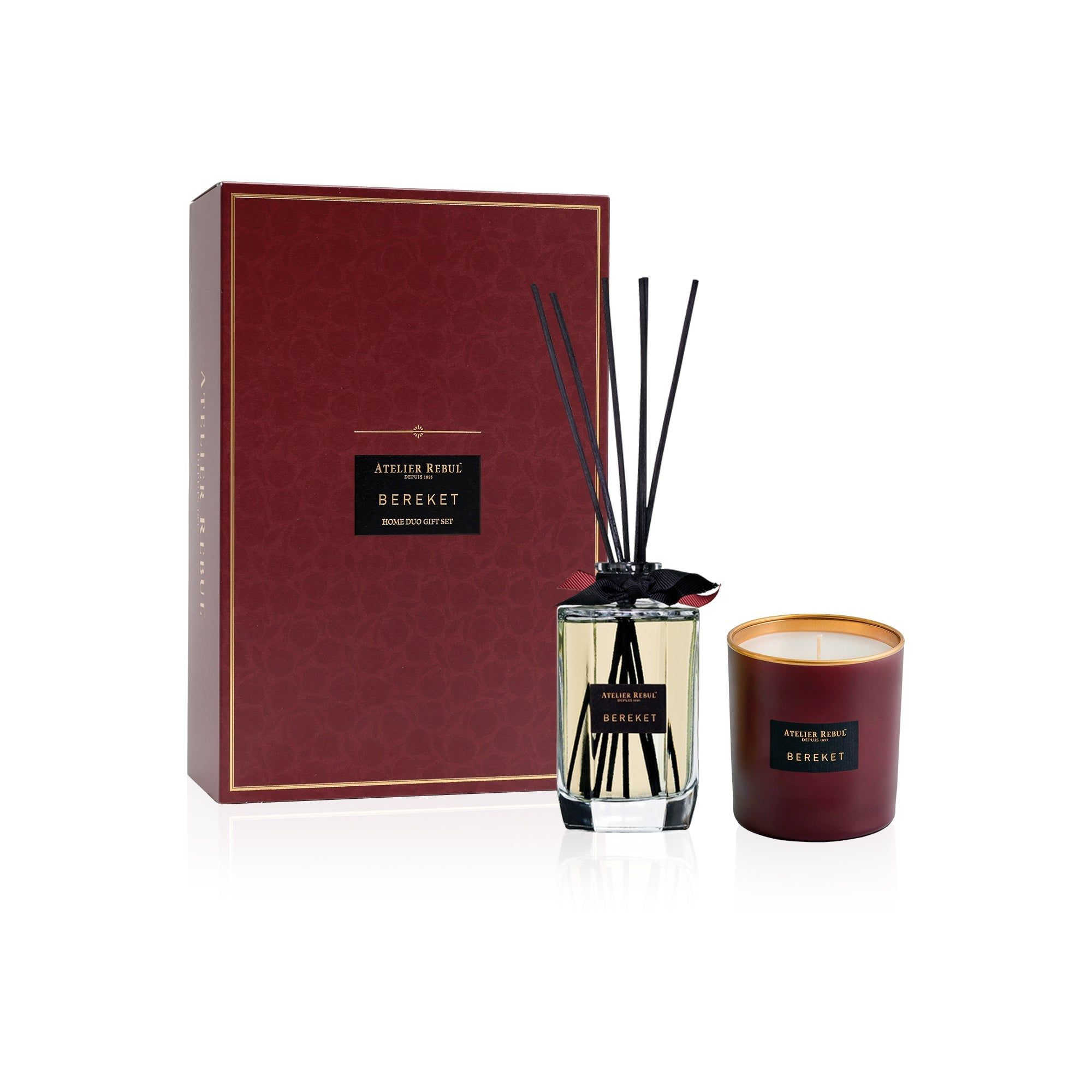 Burgunderrote Geschenkbox mit Duftstäbchen und Kerze. Aufschrift: Atelier Rebul Bereket. Schwarze Stäbchen in Glasflasche.