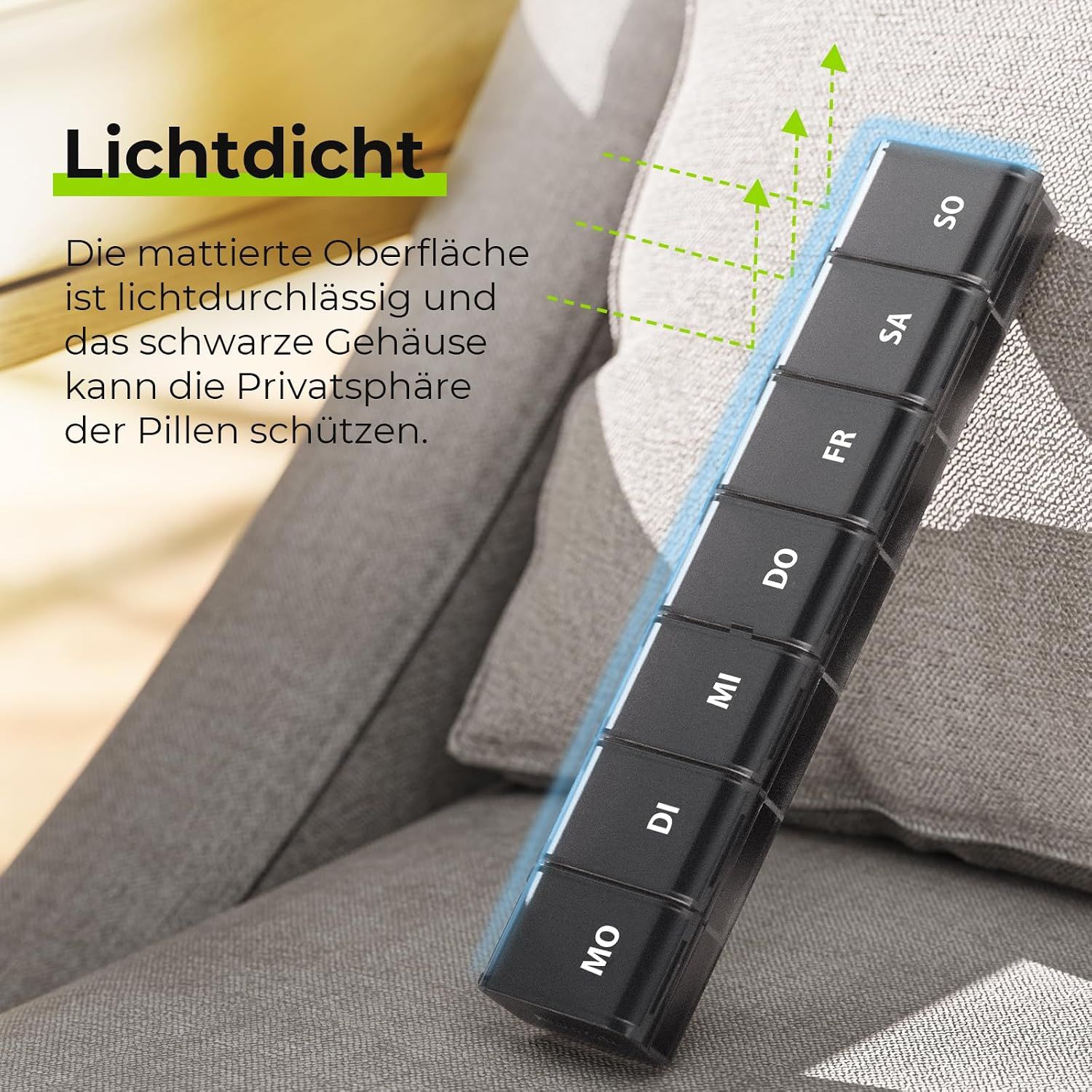 Schwarzer Pillenorganizer mit beschrifteten Fächern für die Wochentage, liegt auf einem grauen Stoff.