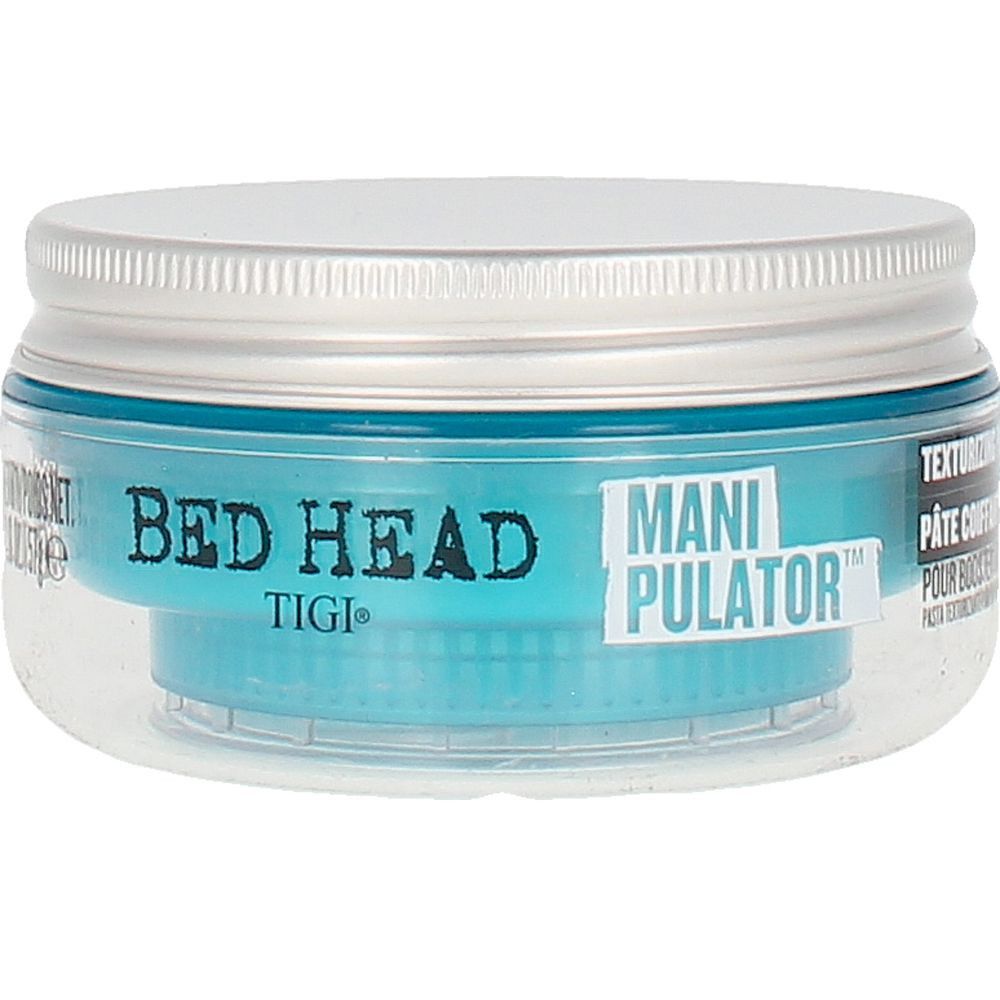 Tigi Bed Head Manipulator Matte Paste. Runde Dose mit blauem Inhalt und silbernem Deckel. Klarer Behälter.