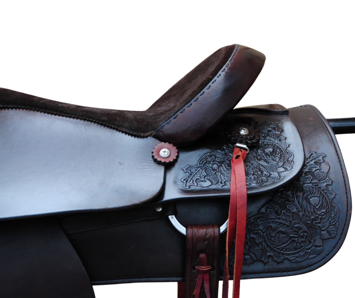 Nahaufnahme eines braunen Sattels mit floralen Gravuren. Braune Sitzfläche, roter Riemen, Metallbeschläge.