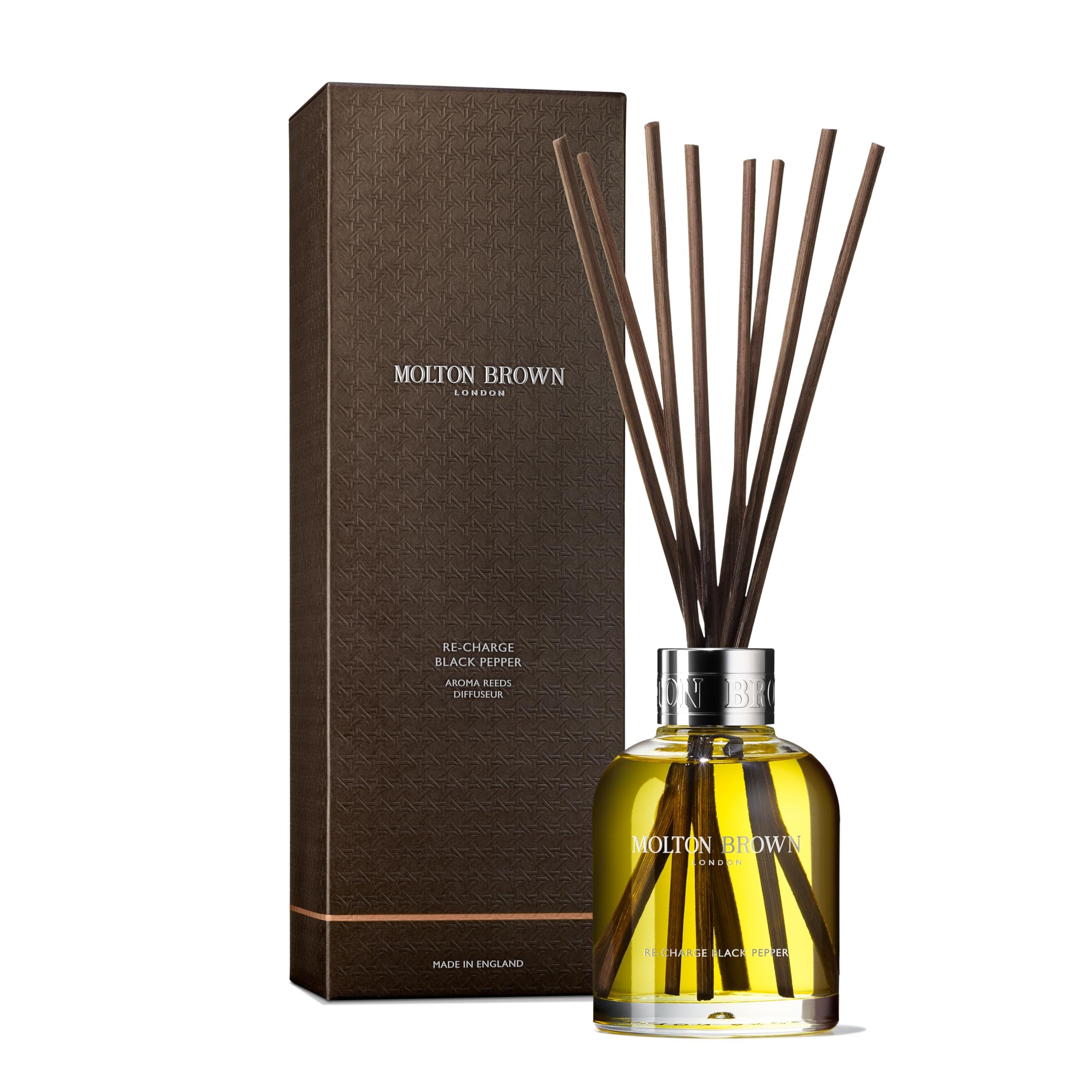 Glasflasche mit Duftstäbchen und brauner Verpackung. Aufschrift: Molton Brown, Re-Charge Black Pepper Aroma Reeds.