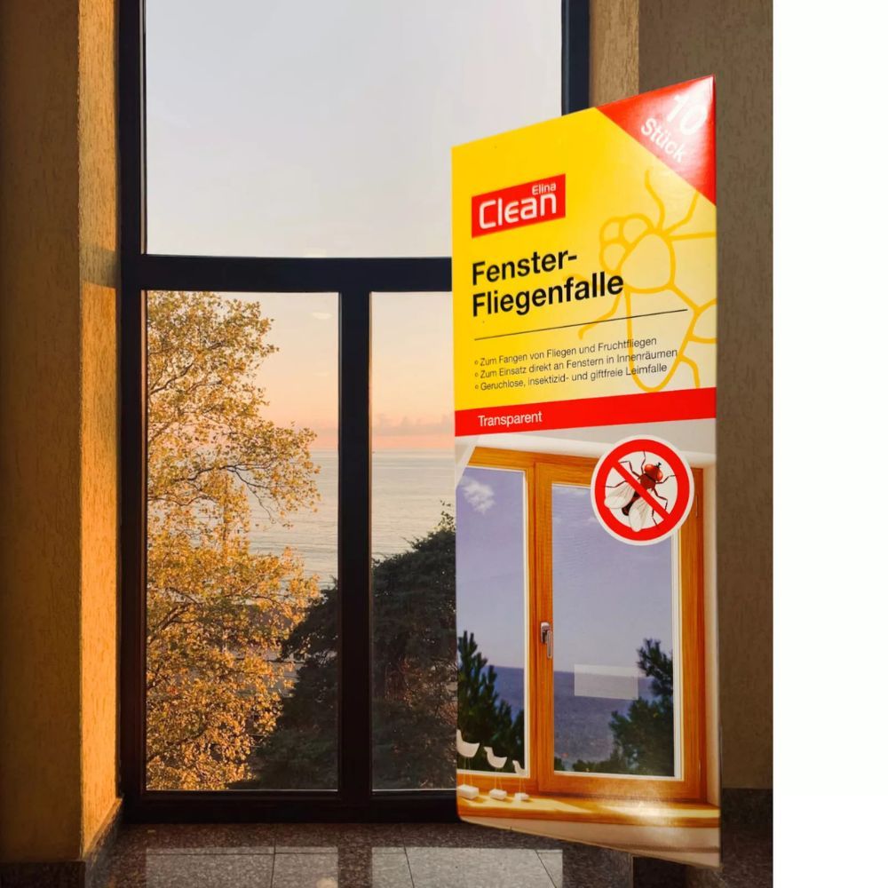 Elina Clean Fenster-Fliegenfalle, gelbe Verpackung vor Fenster. Produktname, Insekten-Symbol und Text. 10 Stück.